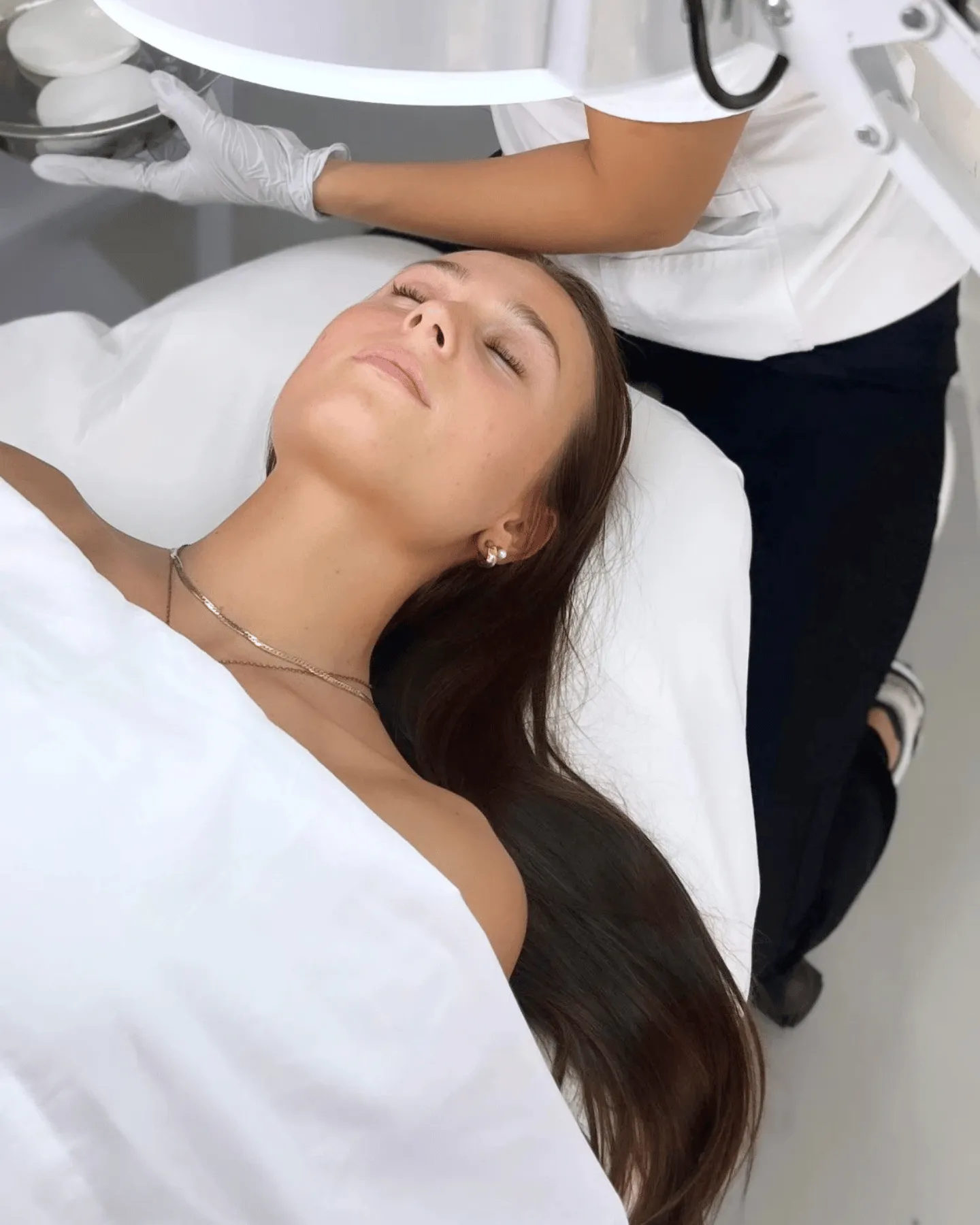 Young woman relaxing with eyes closed during a luxury facial treatment at Project Esty student spa in Gilbert, Arizona