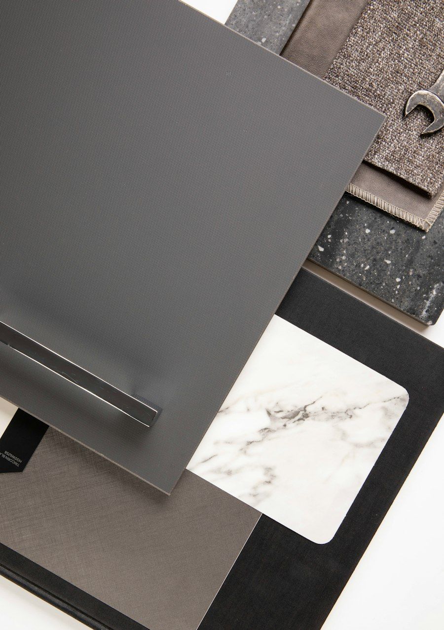 Material samples: dark laminate, white marble and textured stone