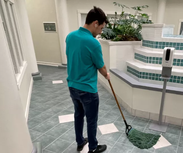 Excel Cleaning technician mopping a commercial tiled floor area