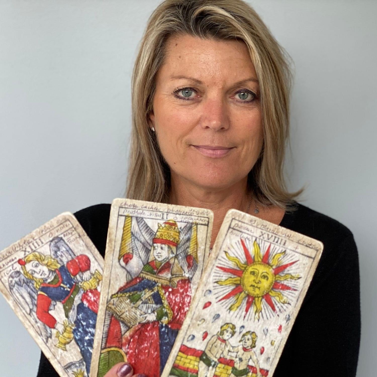 Karyne, tarologue et médium, avec trois lames du Tarot de Marseille