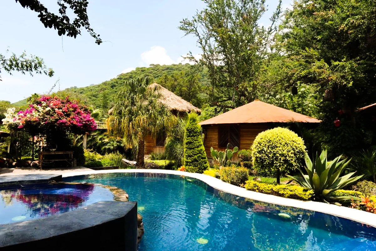 The pool, casitas, and gardens with the hillside behind