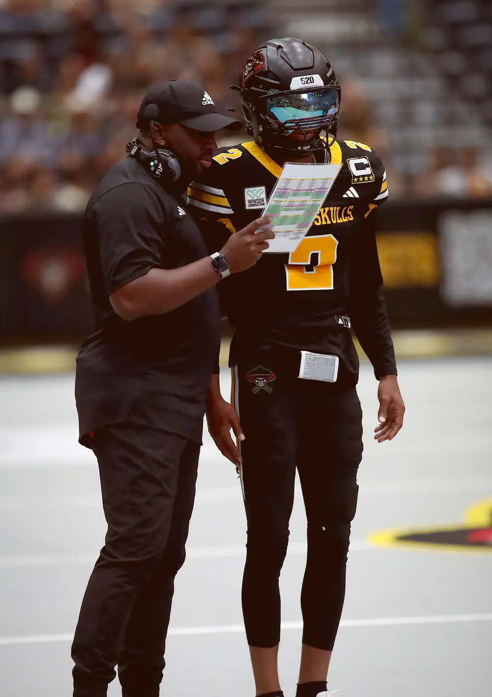 Head coach Kizer going over the call sheet with the Sugar Skulls quarterback