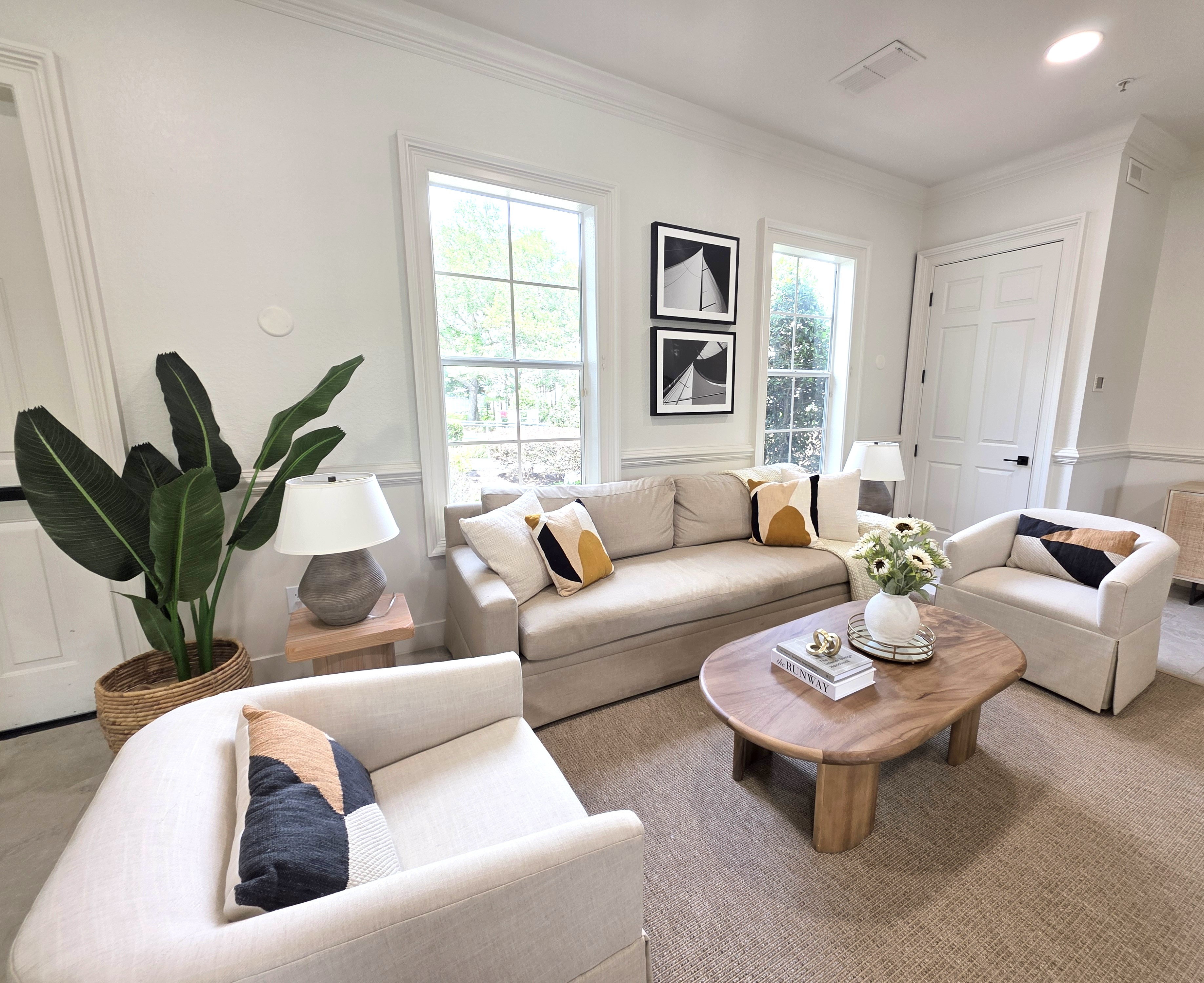 Home staging example with neutral furniture, natural wood accents, and decorative throw pillows that introduce subtle color while preserving a clean, move-in-ready aesthetic.