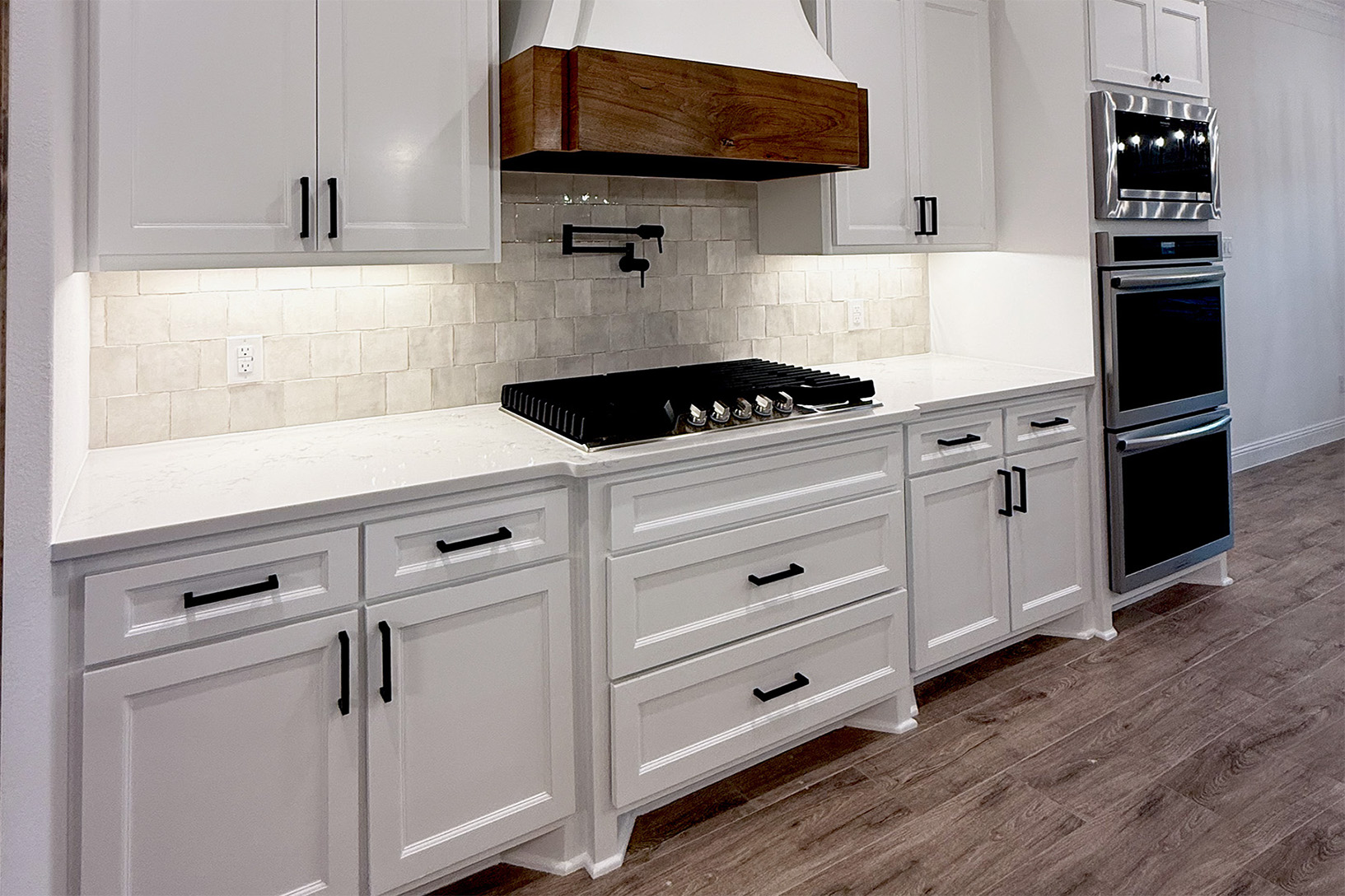 a kitchen with a marble counter top and white cabinets