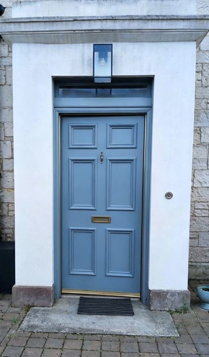 Blue front door in a white stone porch
