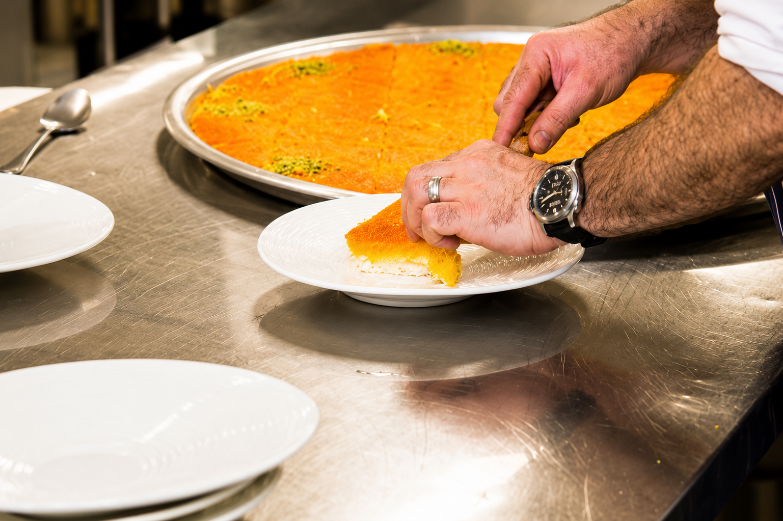 A fresh whole knafeh tray, golden and glistening, ready to be shared