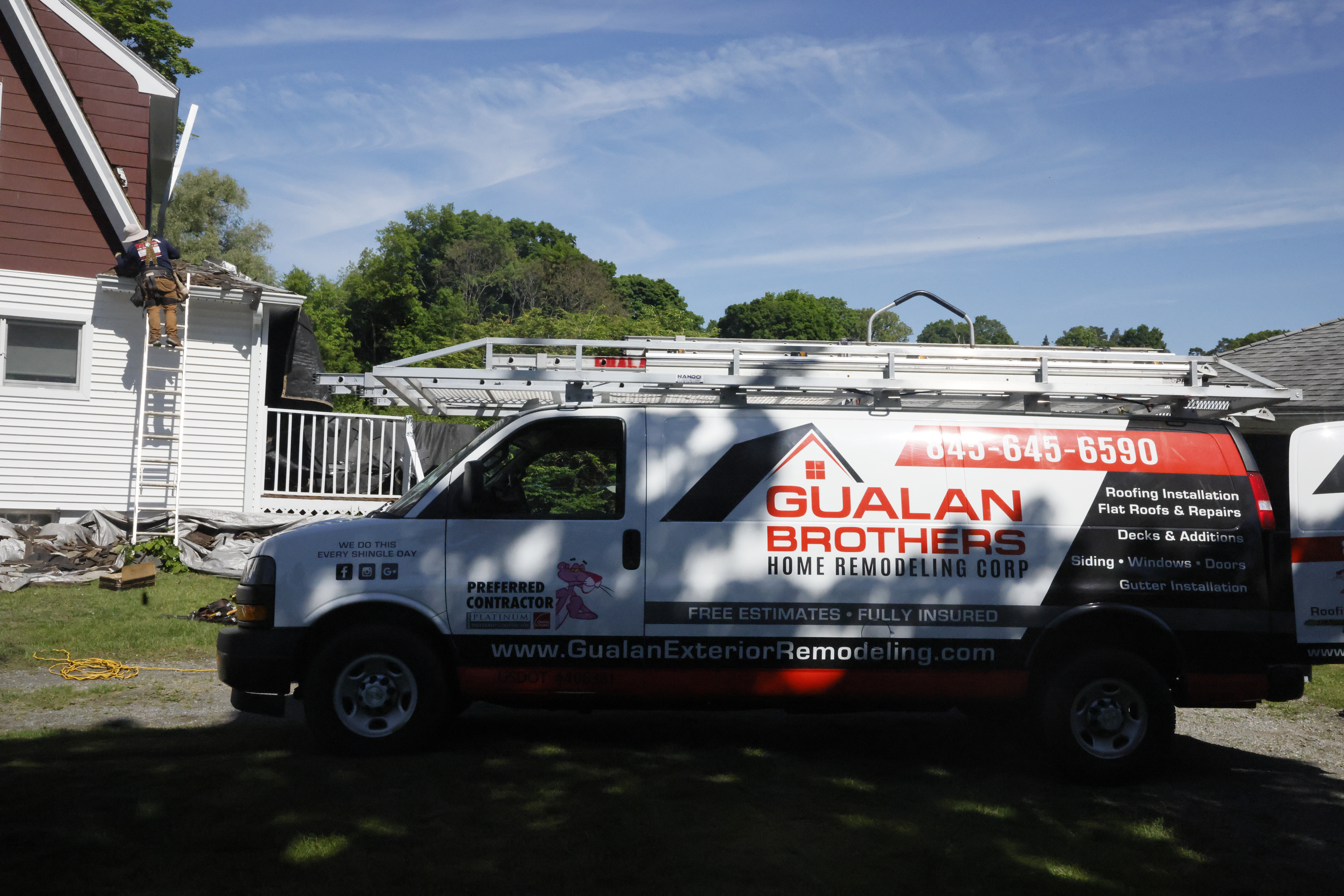 Gualan Brothers roofing contractor truck at a residential roofing project
