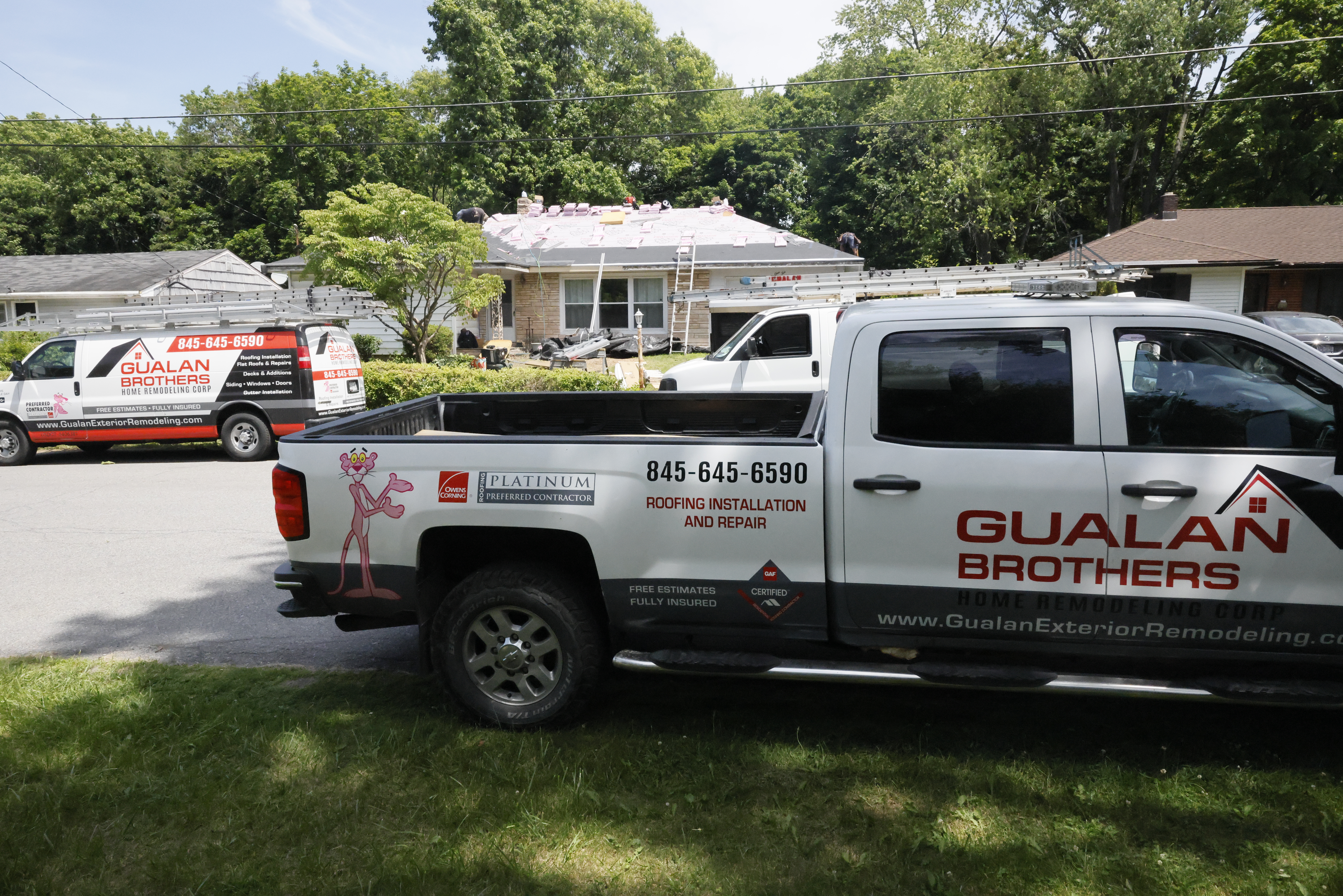 Gualan Brothers crew and trucks at a roofing job site
