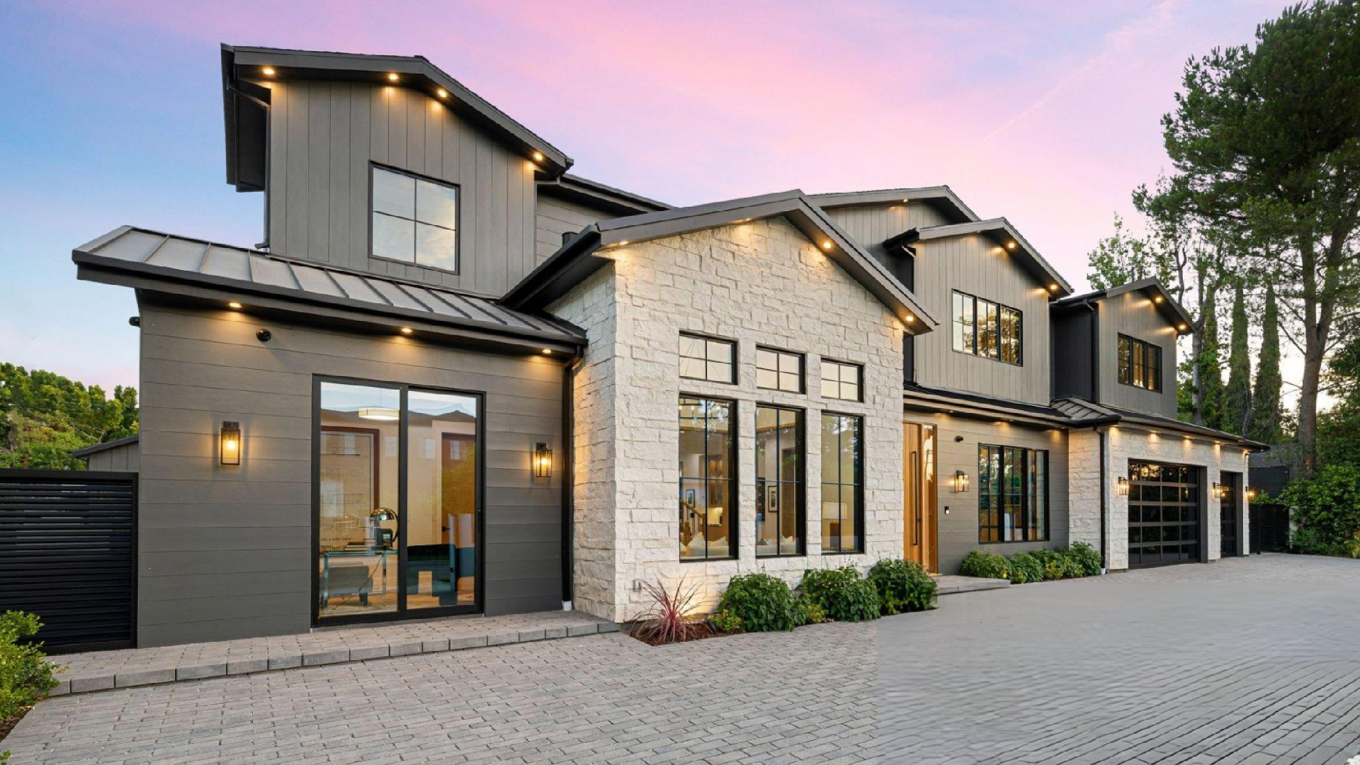 Modern two-story home exterior with black and white siding, large windows, balcony, garage, and landscaping. Modern two-story home exterior with black and white siding, large windows, balcony, garage, and landscaping.
