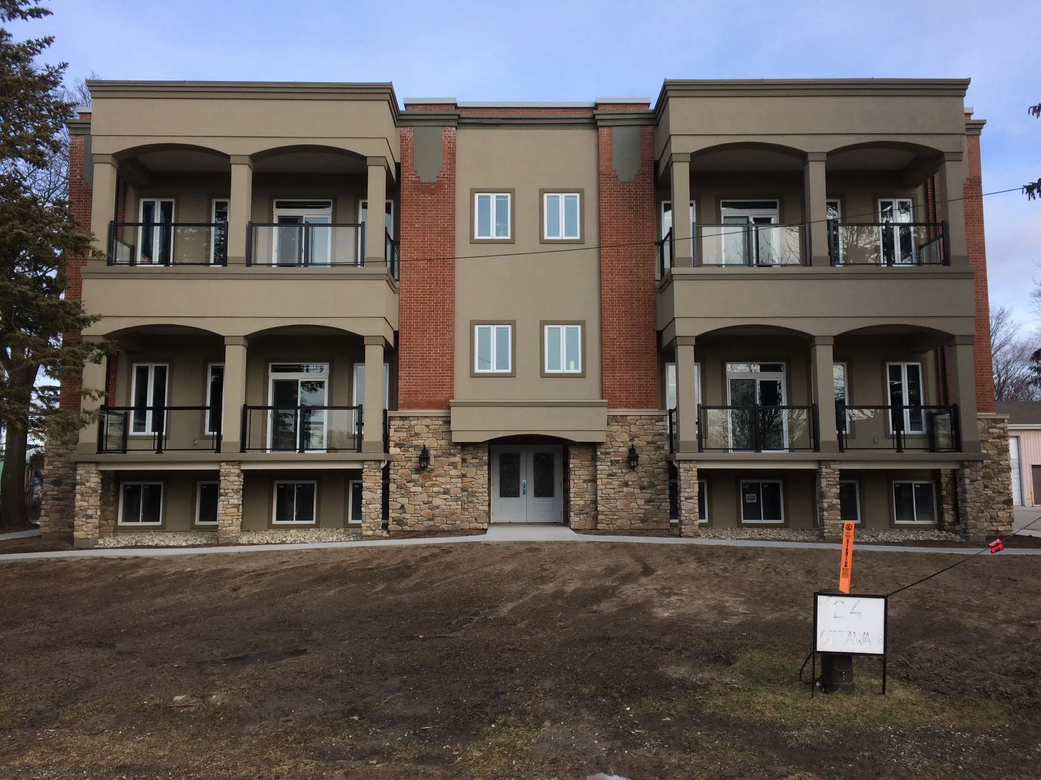 Multi-unit stucco facade with balconies and stone veneer — Norfolk County