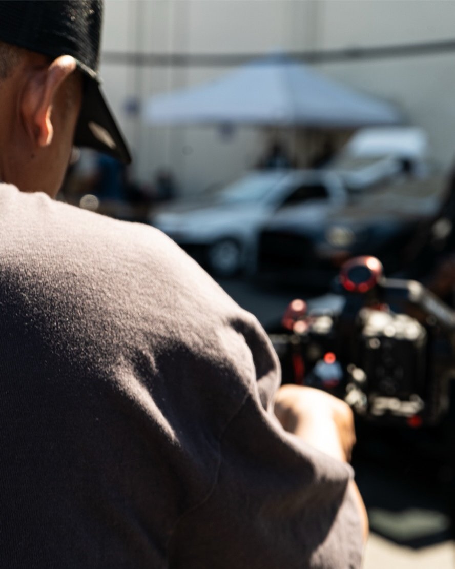 Over the shoulder view of an attendee looking at a car engine bay blurred in the background