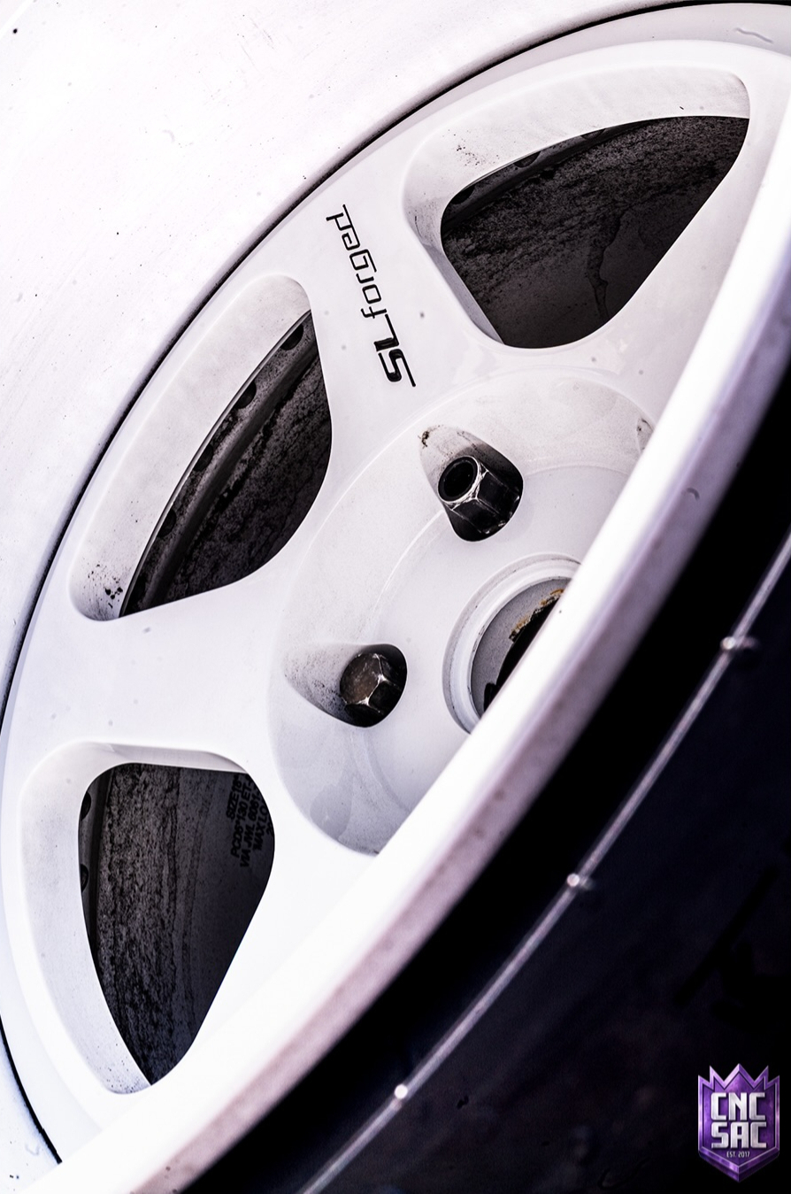 Close up of a white wheel with model lettering on the spoke