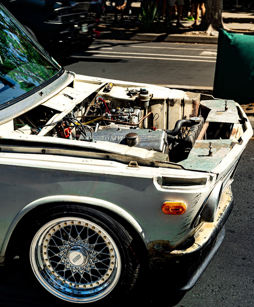 Weathered race car with its hood raised engine bay exposed