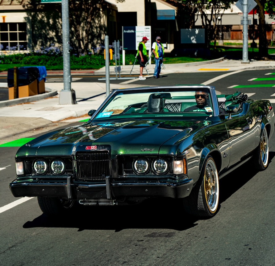 Dark green classic convertible parked on a city street