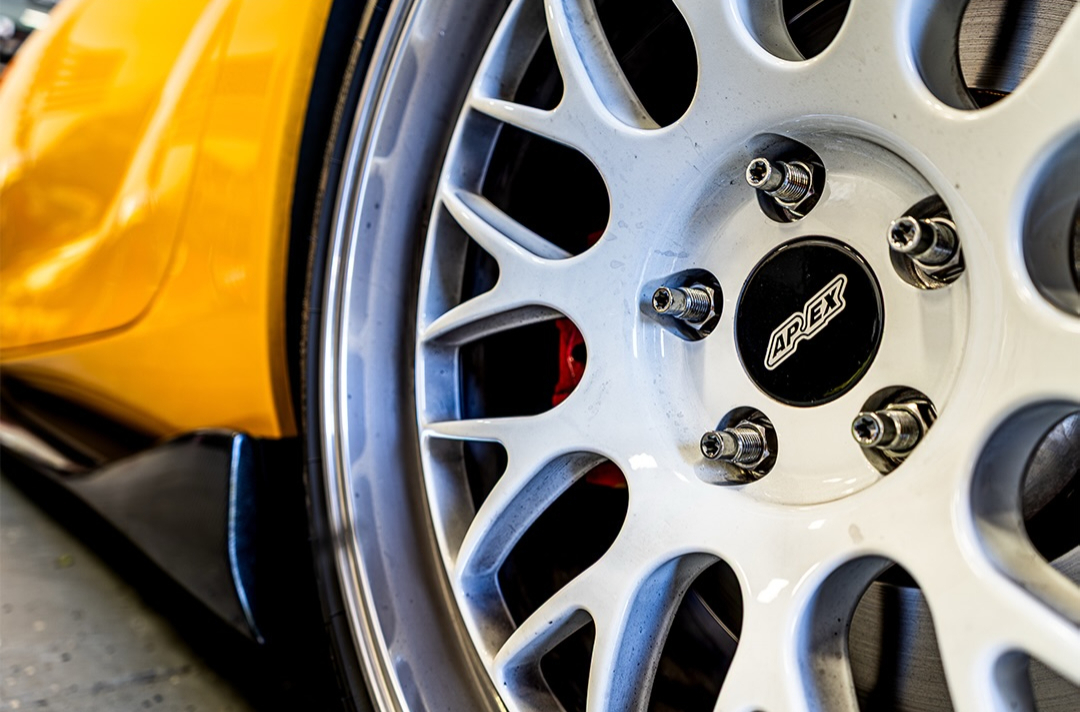 White multi spoke wheel against yellow bodywork shot close