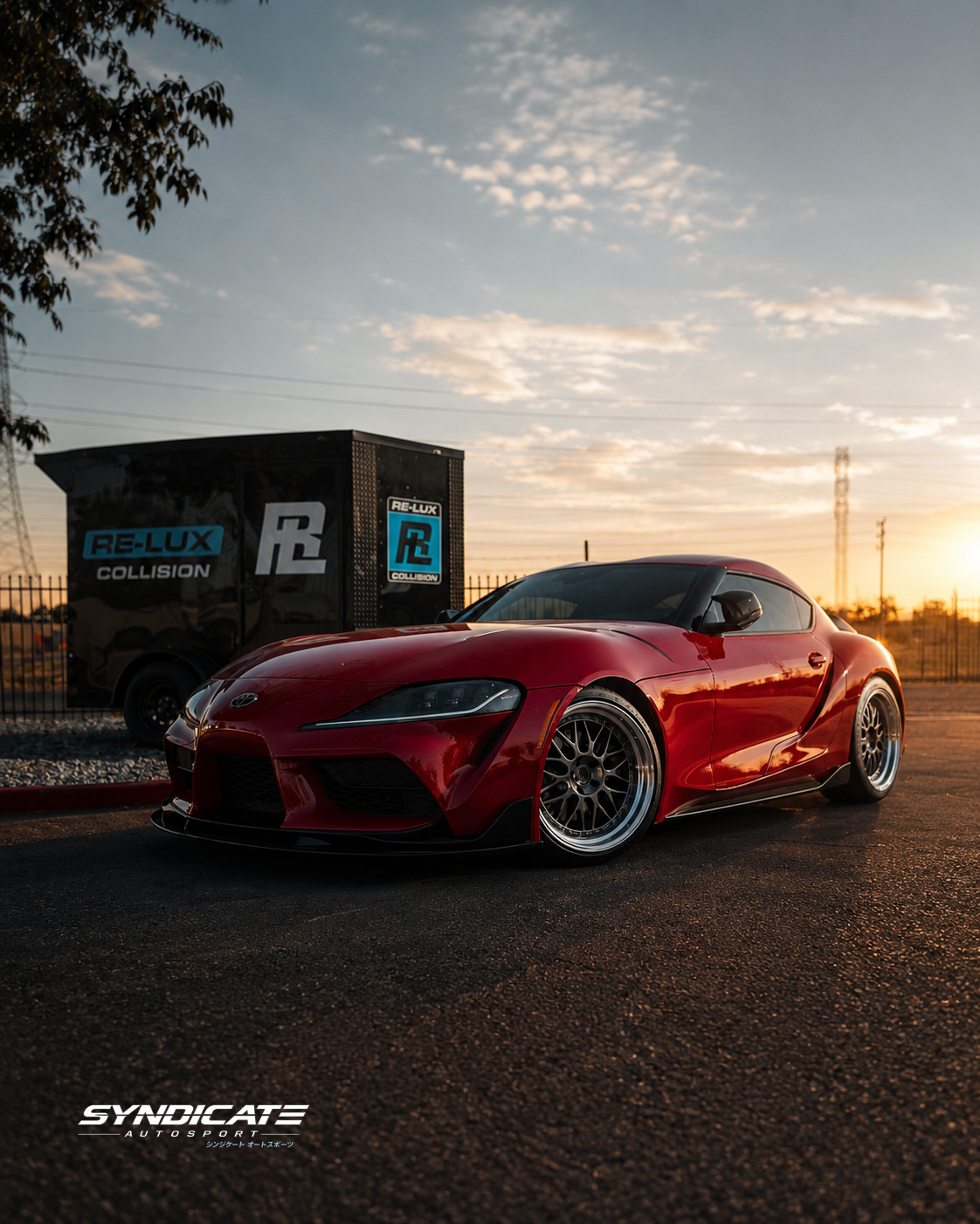 Red Toyota GR Supra at sunset beside the Re-Lux Collision trailer