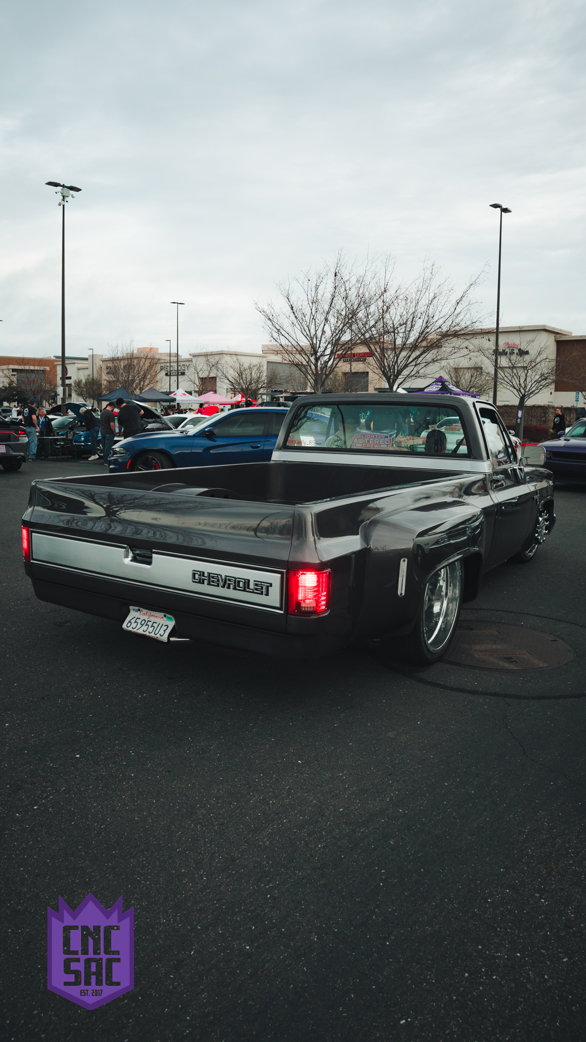 Lowered classic pickup, rear view, at an event