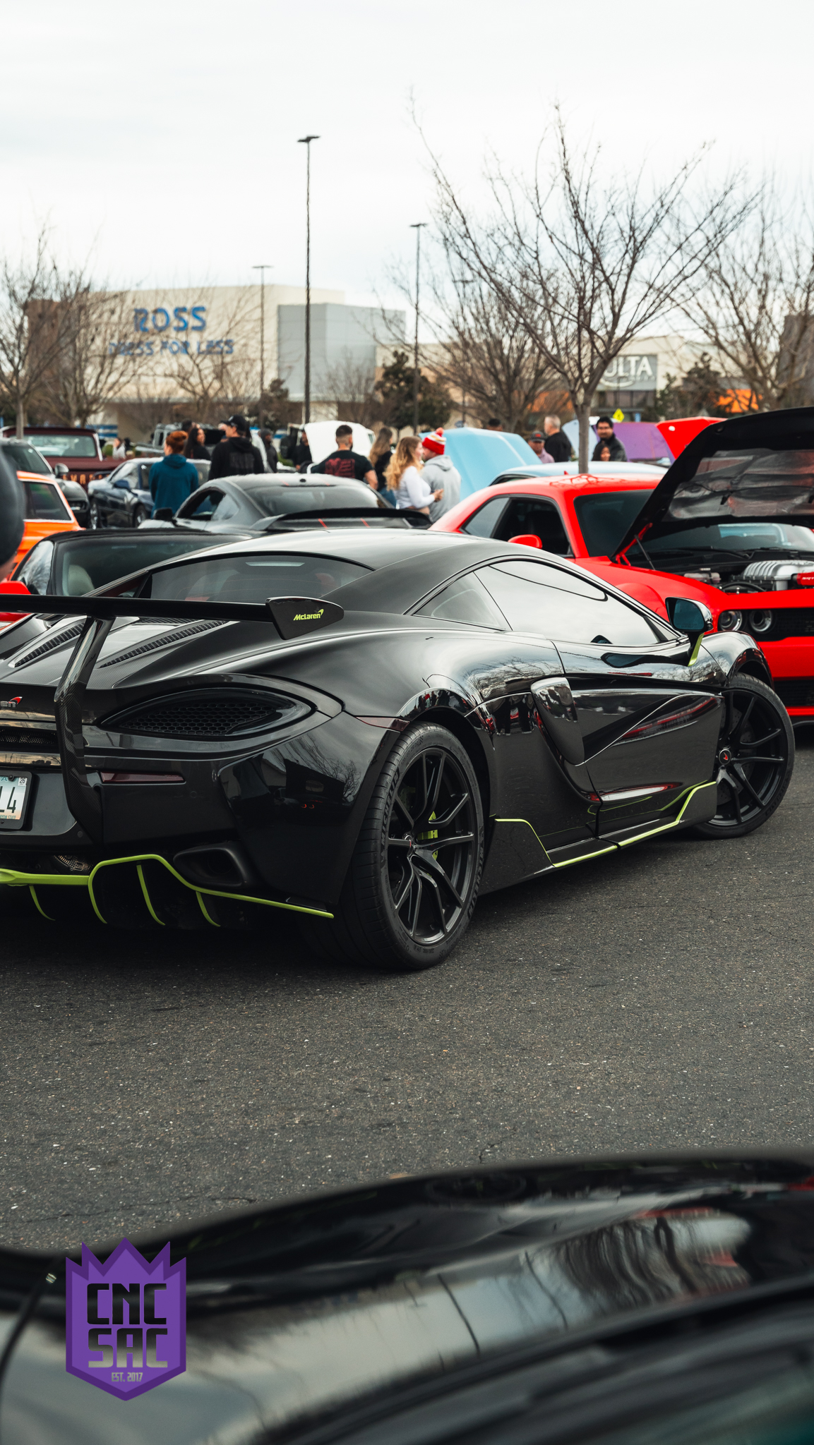 Black supercar, rear three quarter, parked at an event