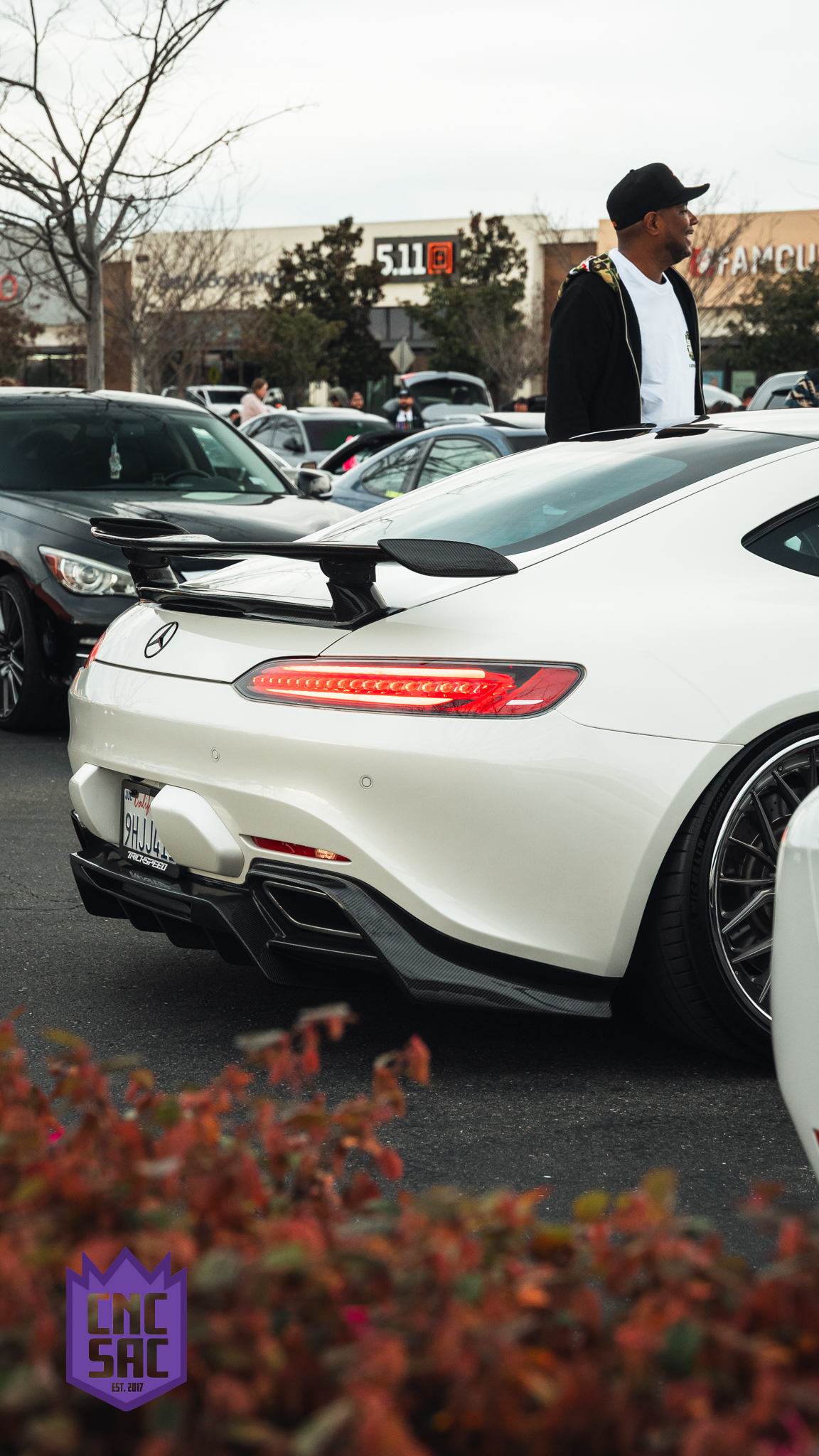 White Mercedes AMG GT with a rear wing, rear three quarter