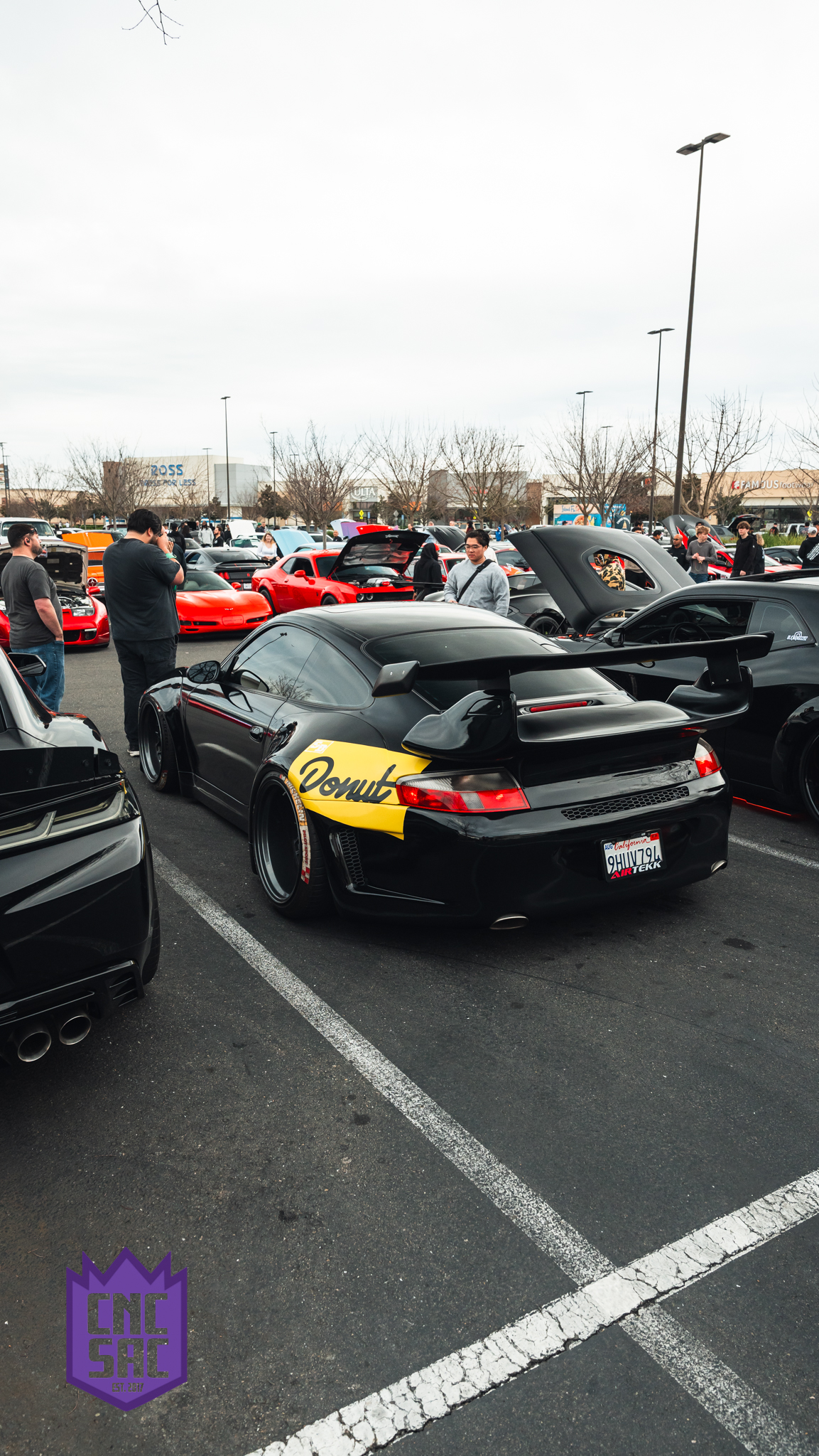 Black Porsche 911 with a rear wing, parked at an event