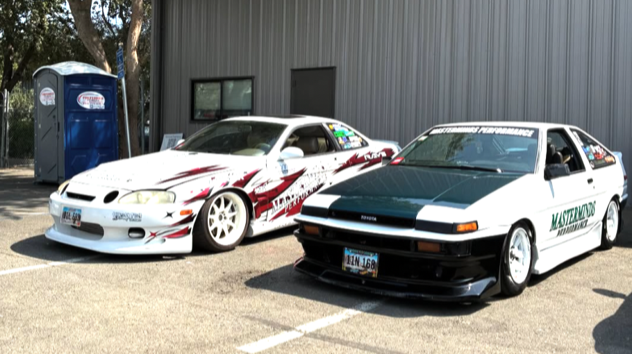 Two cars outside the Masterminds Performance building, one wearing Masterminds branding