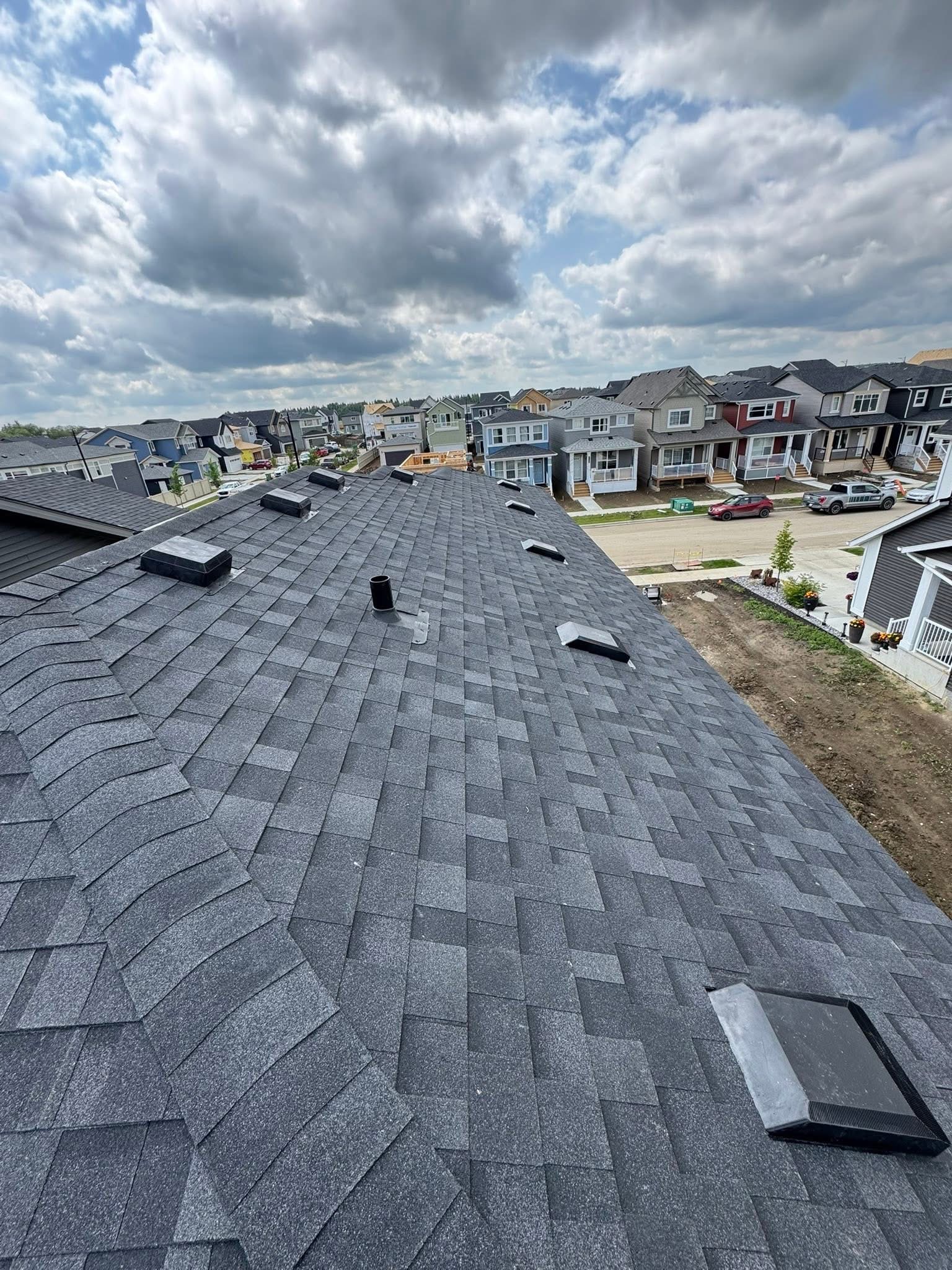 Residential roof in a neighborhood under a cloudy sky