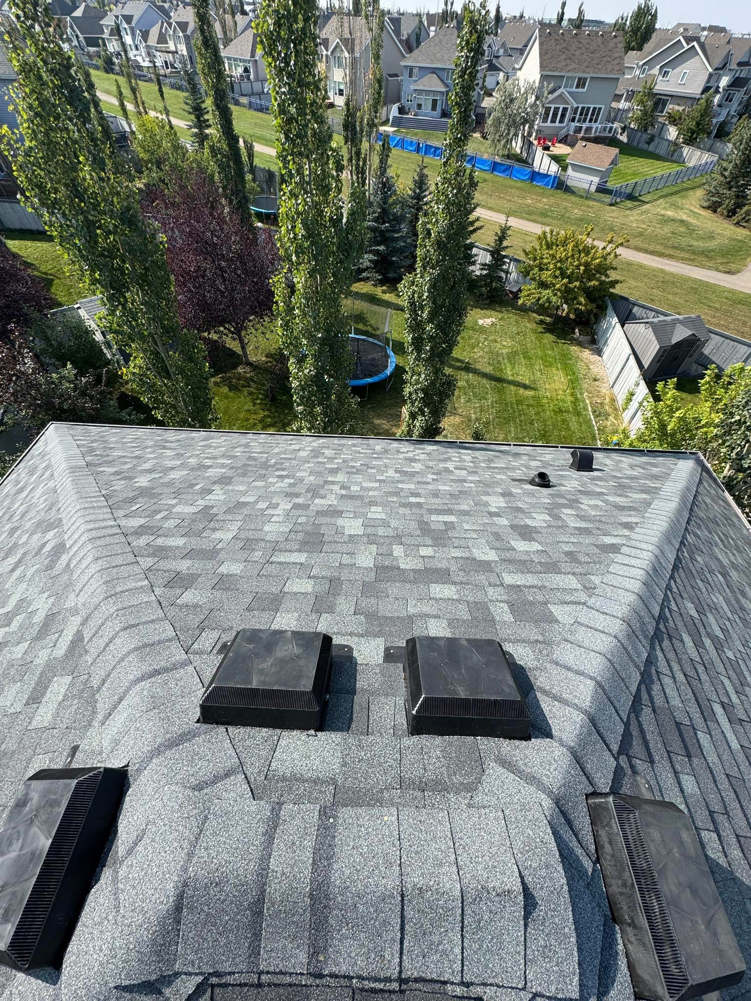 Residential roof with vents and gray shingles during an inspection