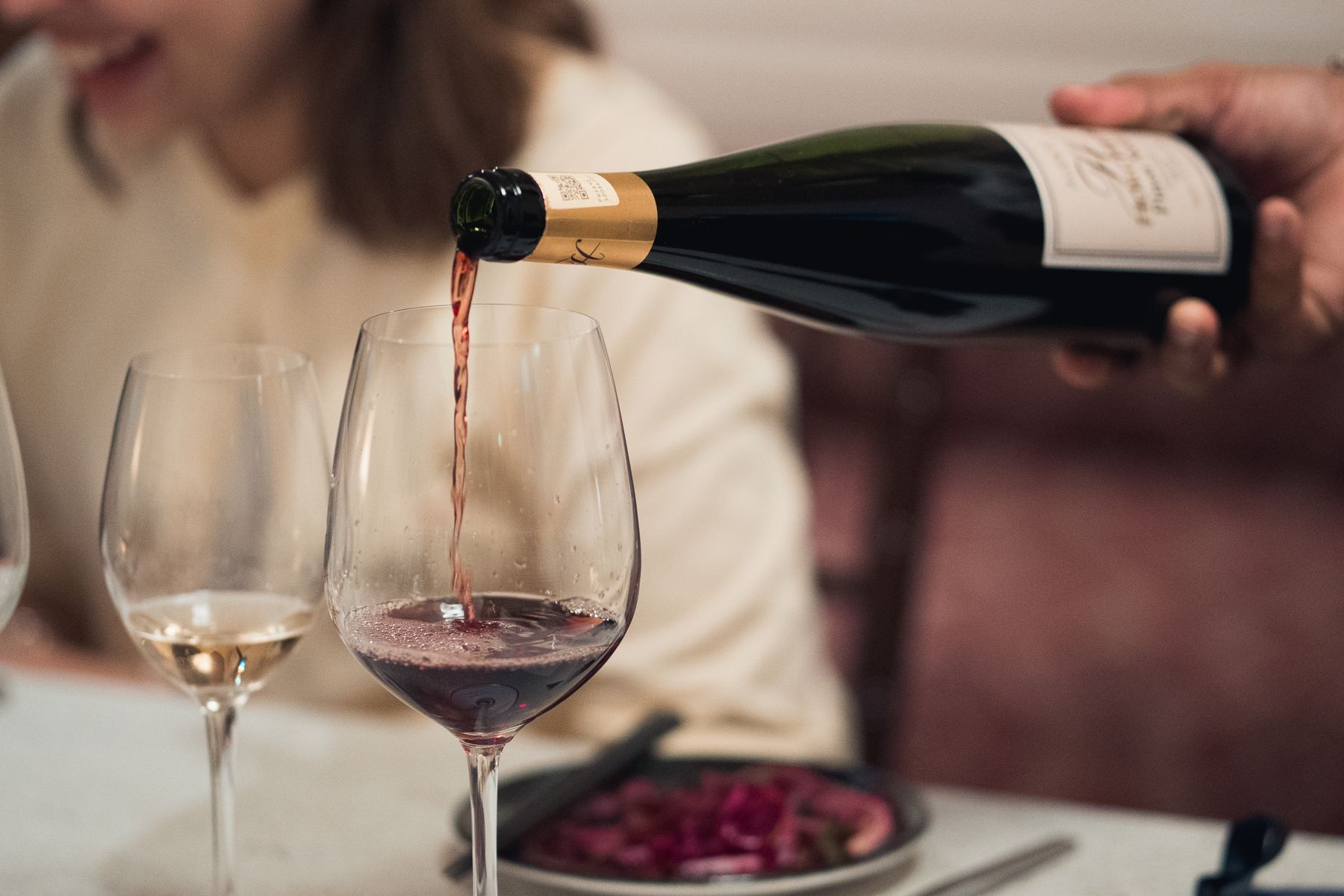 Red wine being poured at a 3nity tasting