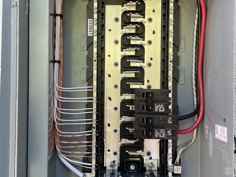 Interior of an aged electrical panel with crowded breakers
