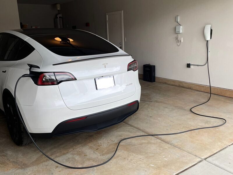 Tesla plugged into a Level 2 home charger in a garage