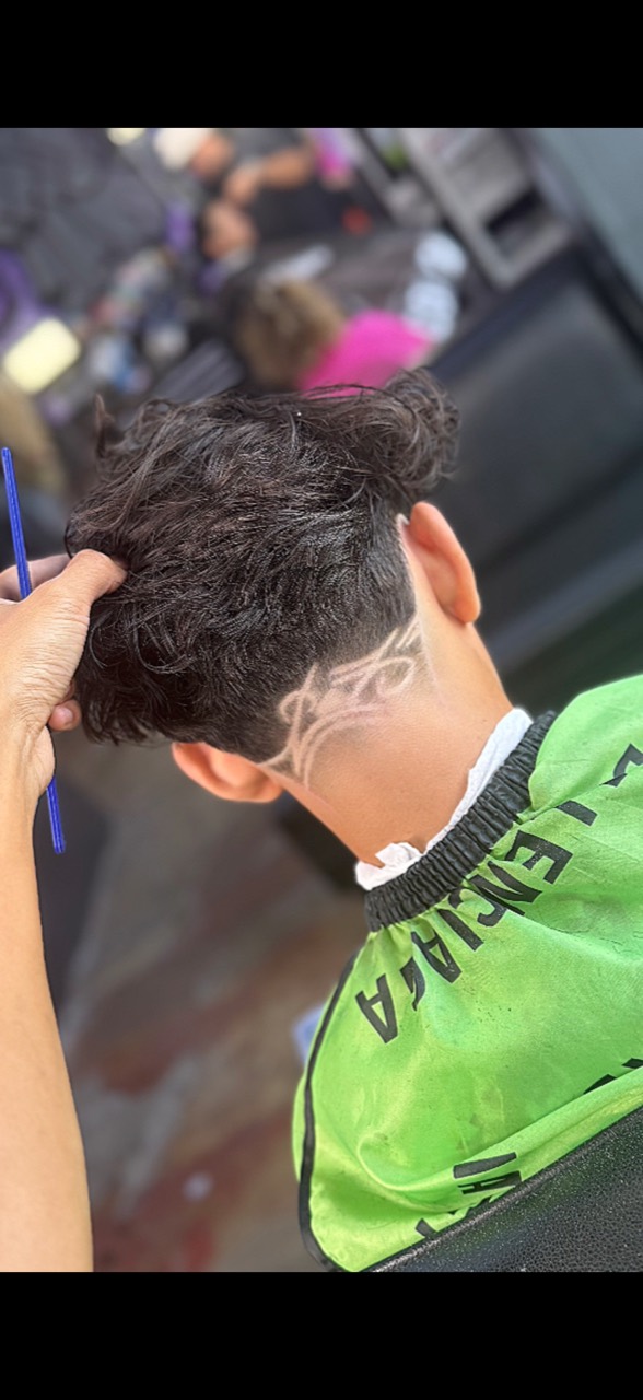 Rear view of a haircut featuring an angular shaved design above the neckline.