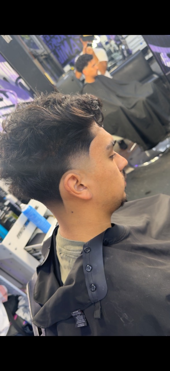 Side profile with a voluminous dark textured top and a close blended side.