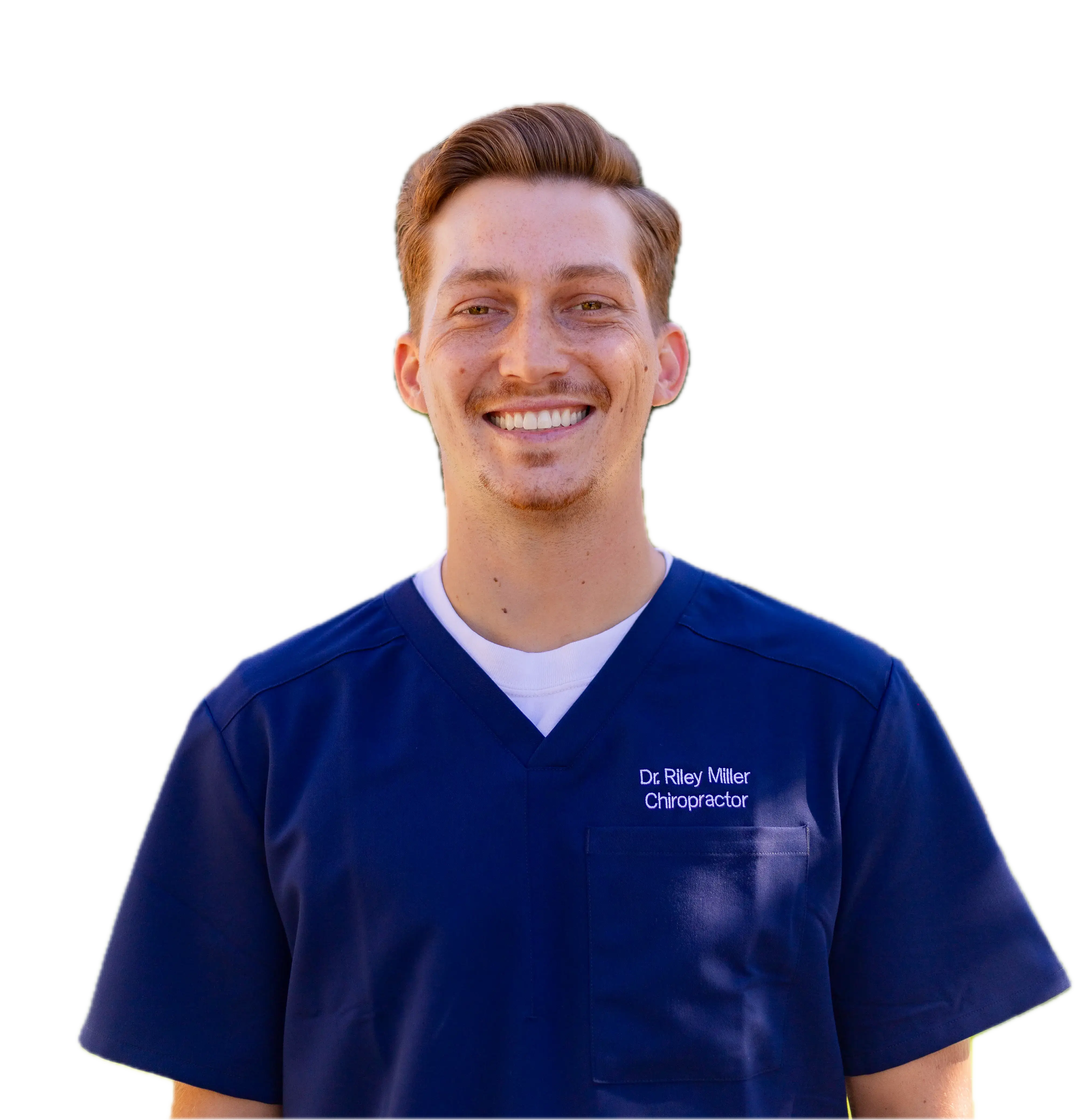 Dr. Riley Miller, chiropractor at Miller Chiropractic and Wellness in Alameda, smiling outdoors in a blue uniform, specializing in spine health and patient care