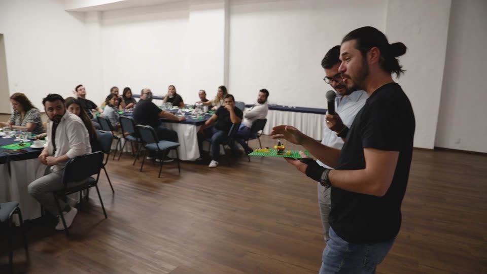 Un participante explica su modelo al grupo con micrófono