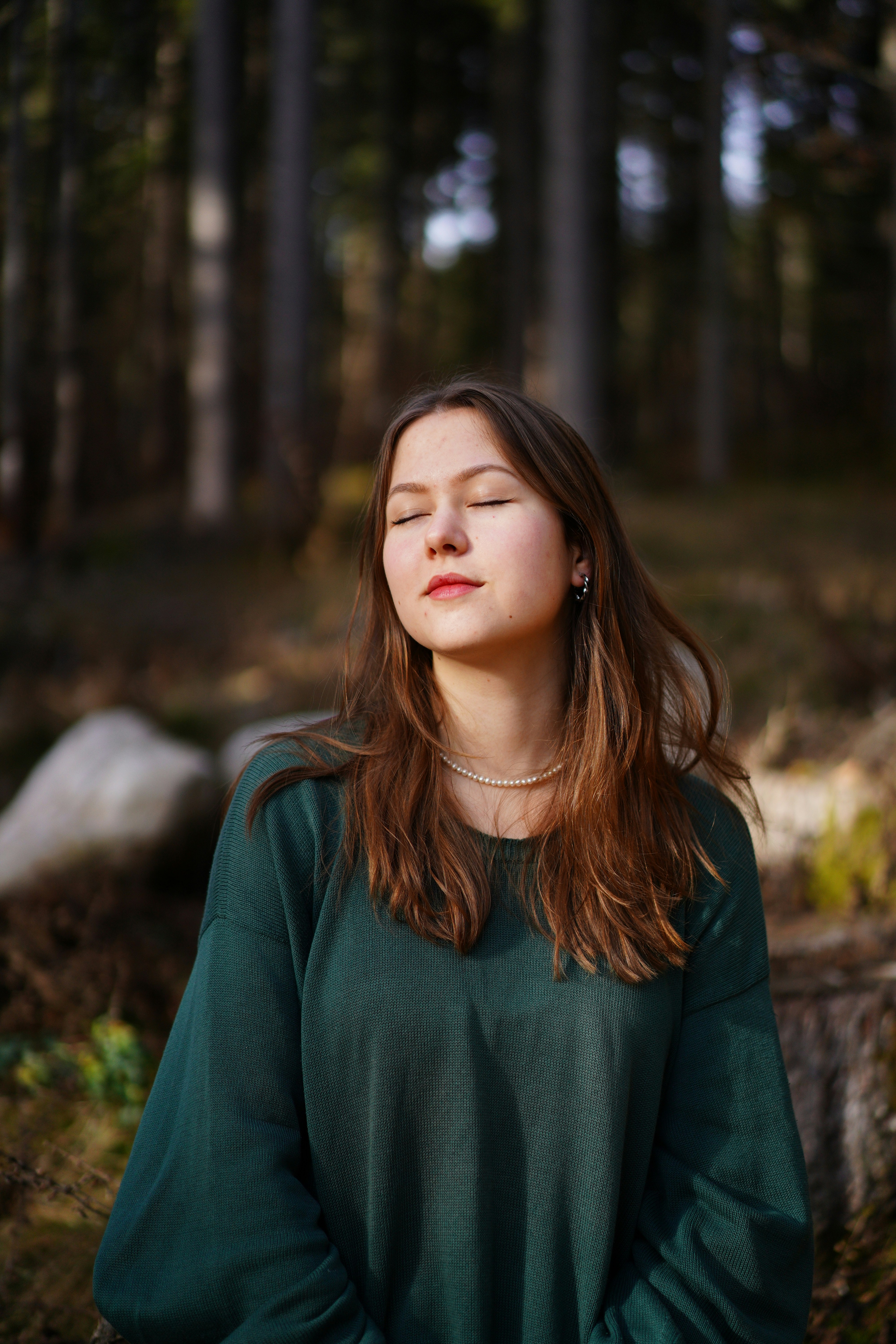 woman sitting nature eyes closed peaceful grounded