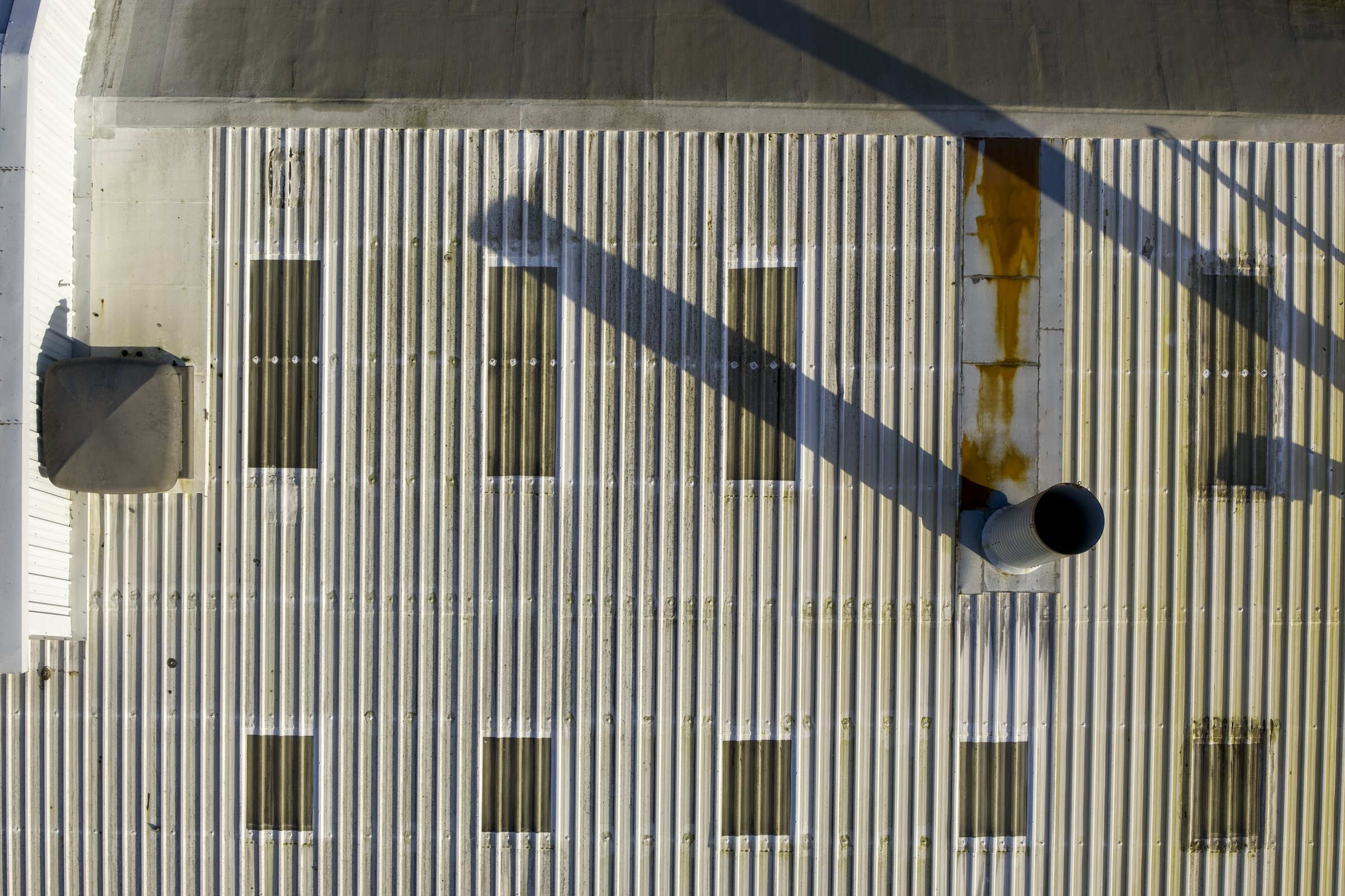 Corrugated roof section showing rust streaking, a sign of trapped moisture beneath the surface Corrugated roof section showing rust streaking, a sign of trapped moisture beneath the surface