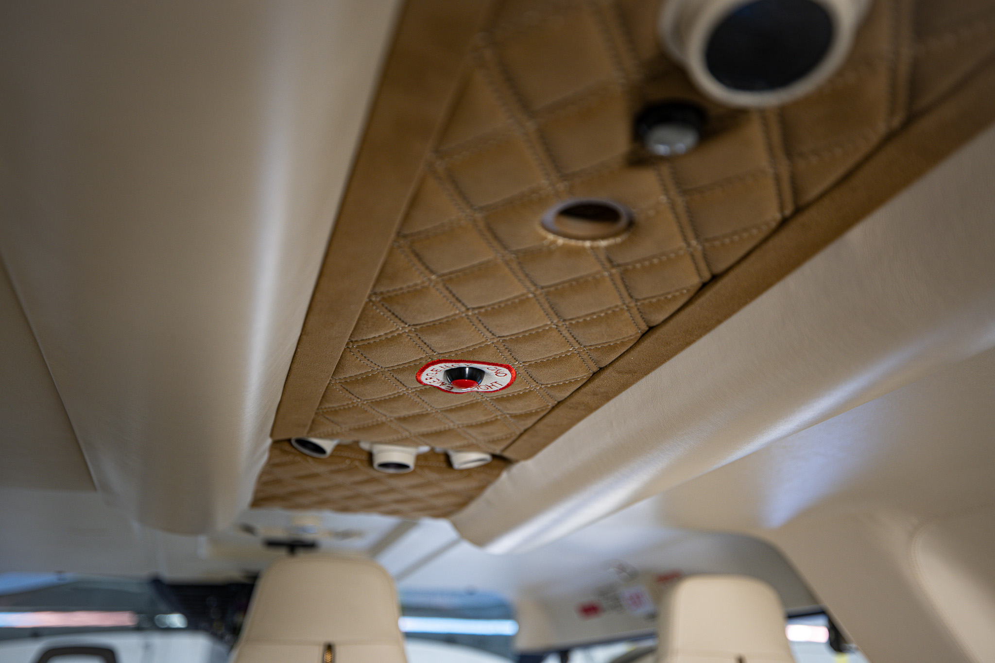 Diamond-quilted brown suede headliner detail with light and air vents