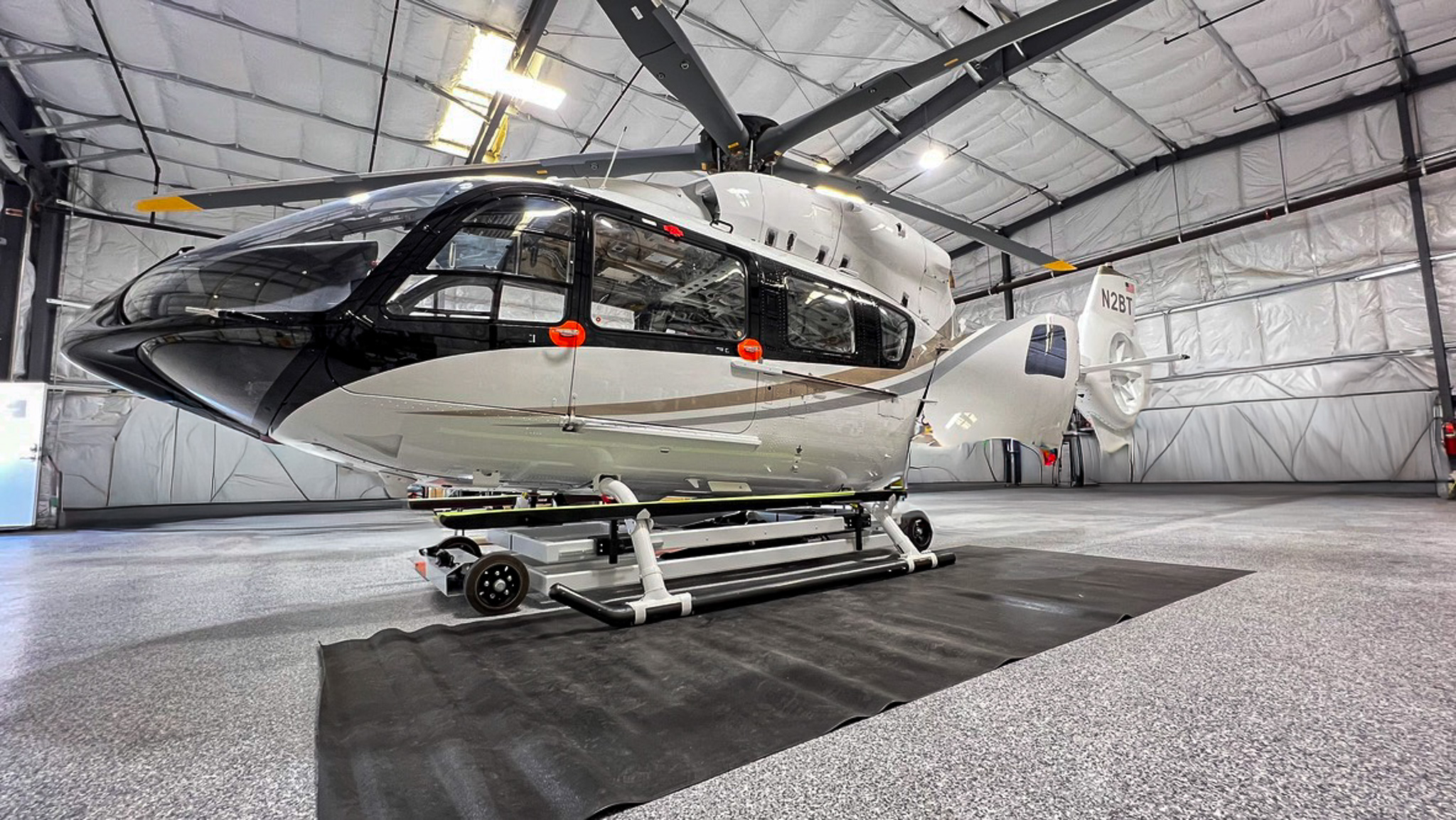 Finished Airbus H145 helicopter in black and white livery, parked in a hangar after a complete interior rebuild