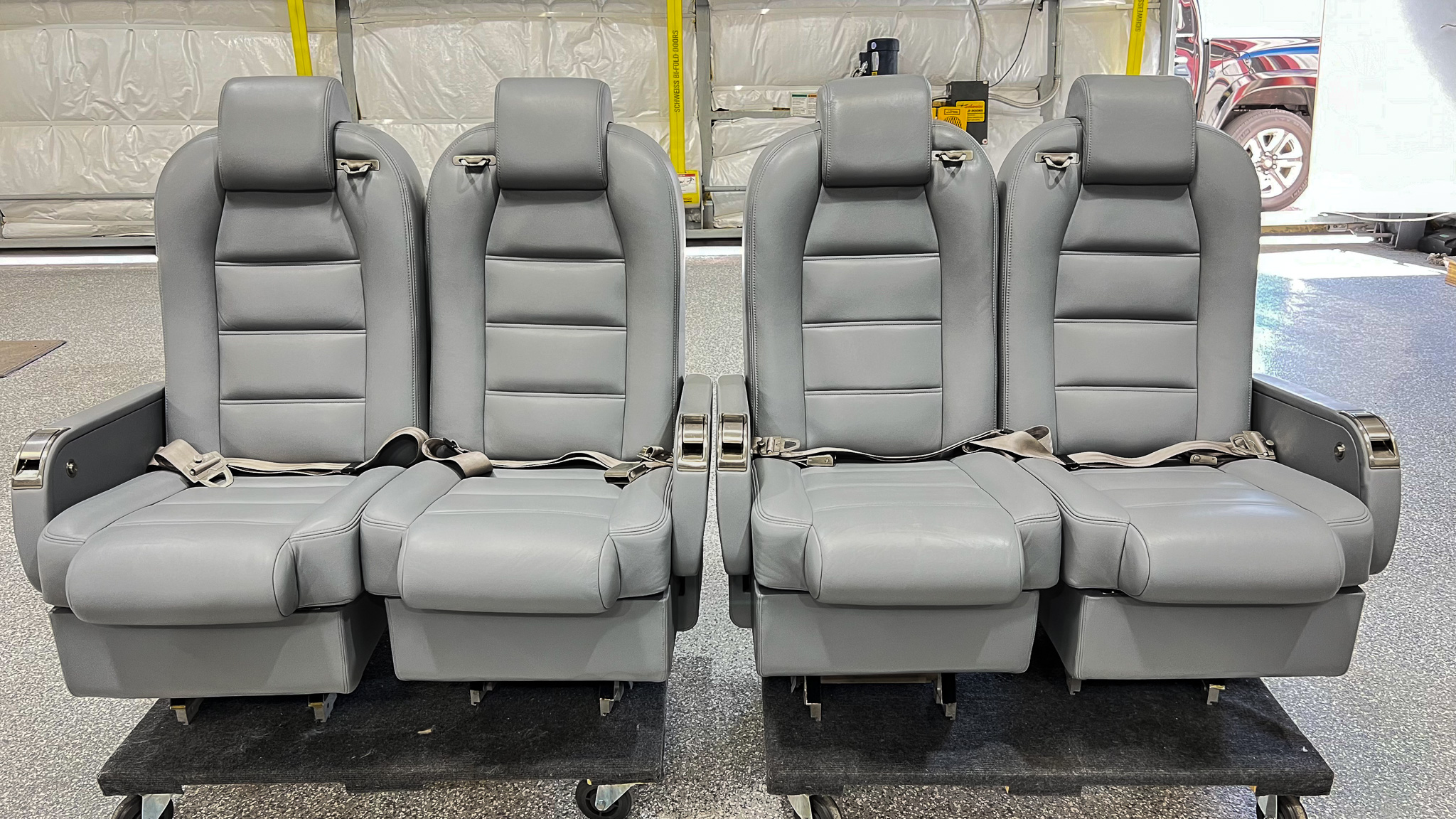 Row of four passenger seats freshly upholstered in the shop