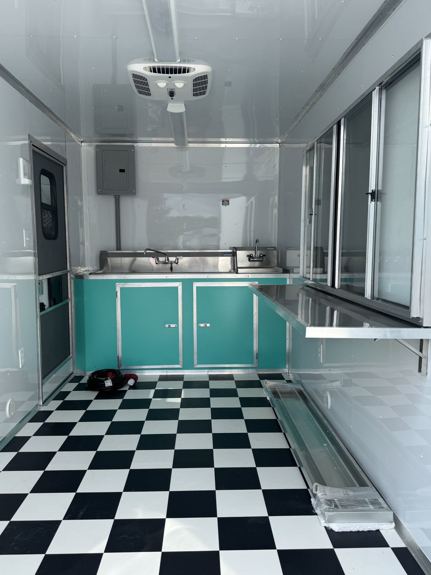 Custom cabinetry and stainless countertops in a Devil Dog Trailers build