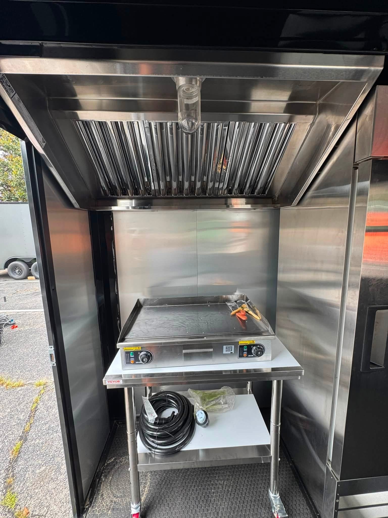 Cooking equipment and exhaust hood in a Devil Dog Trailers concession build