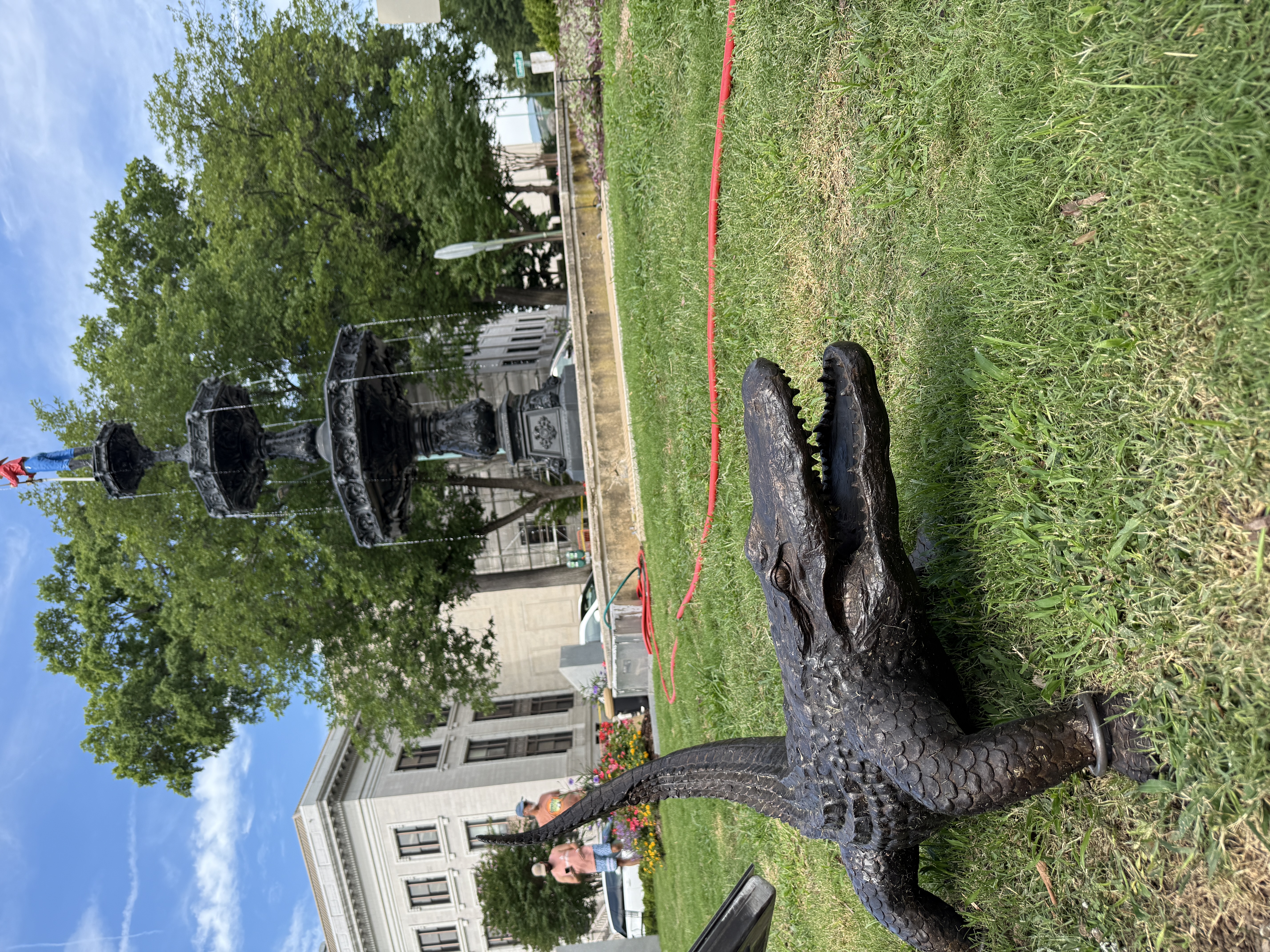 Bronze alligator sculpture in Fountain Square with Fireman's Memorial Fountain in downtown Chattanooga, Tennessee.