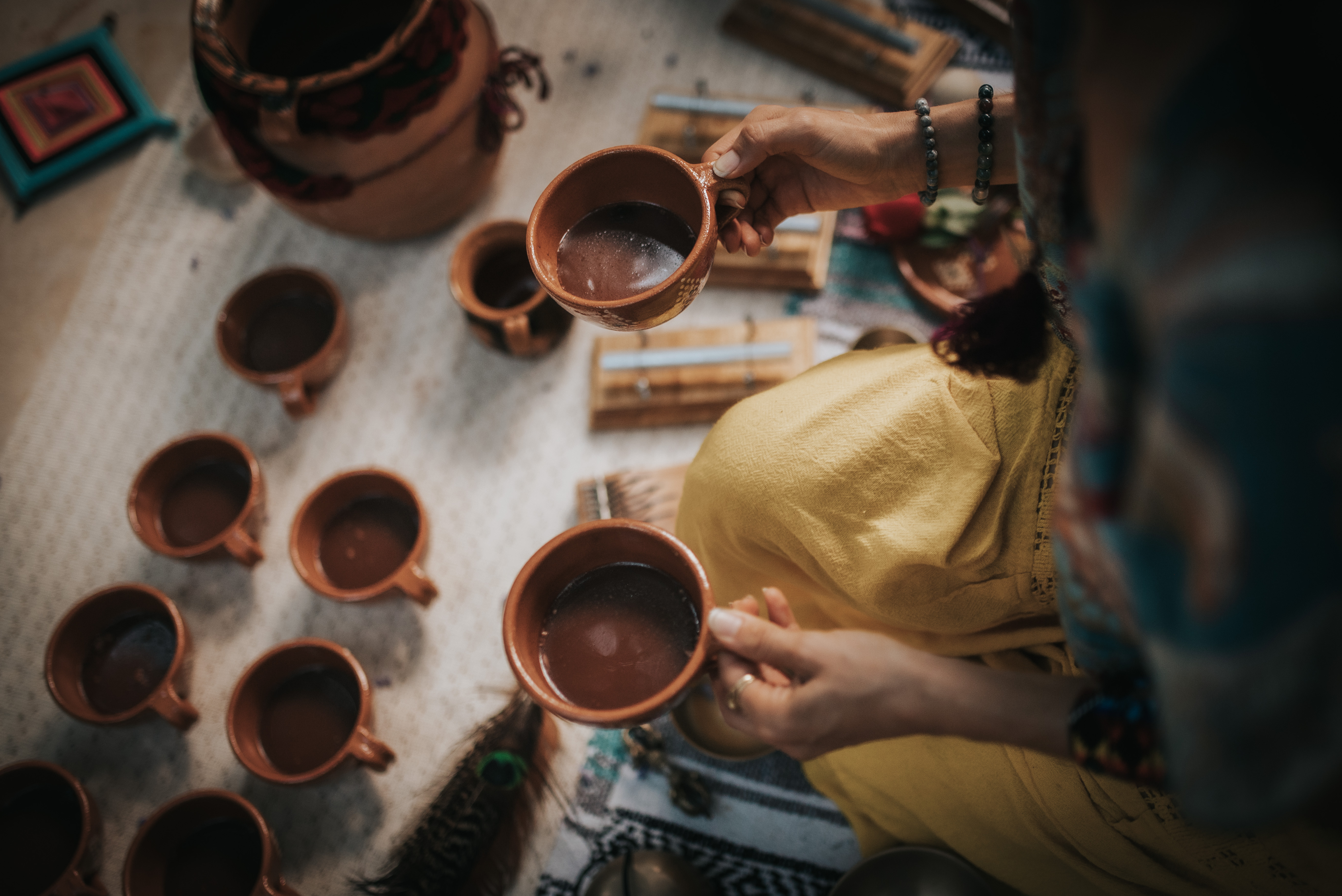 Hand holding a small bowl with a cacao offering
