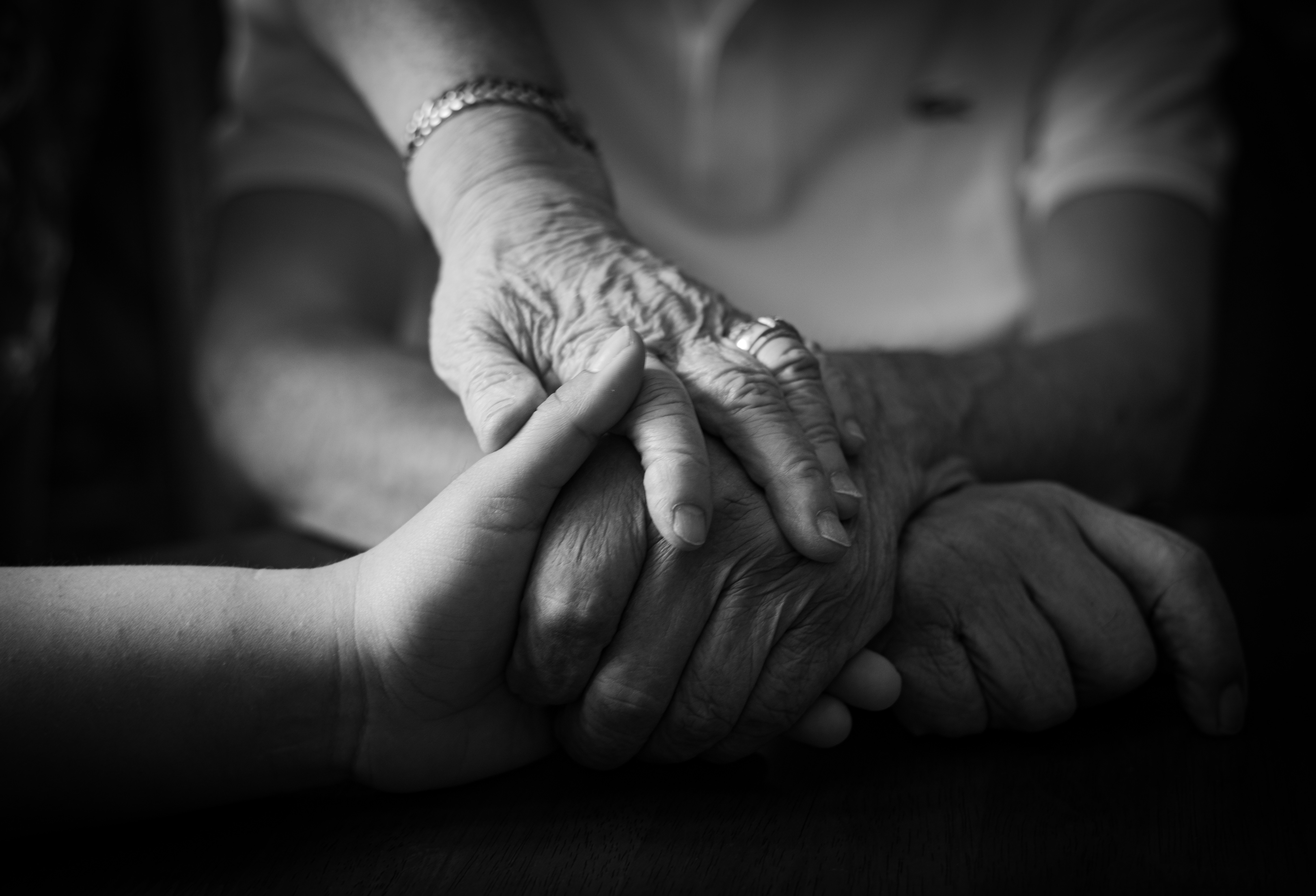 Caregiver and elderly client holding hands in a moment of compassion