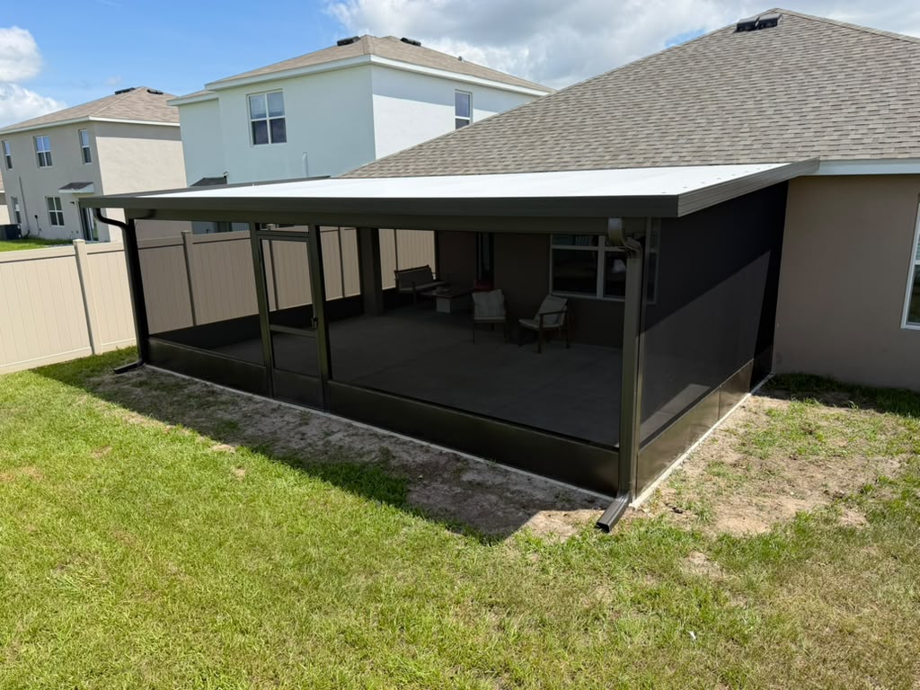 Wide view of a screened outdoor seating area beside a home