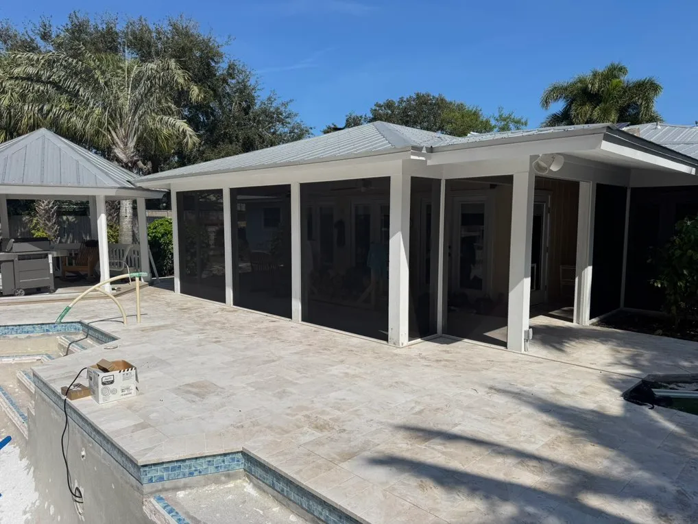 White framed screening around a covered patio beside a pool