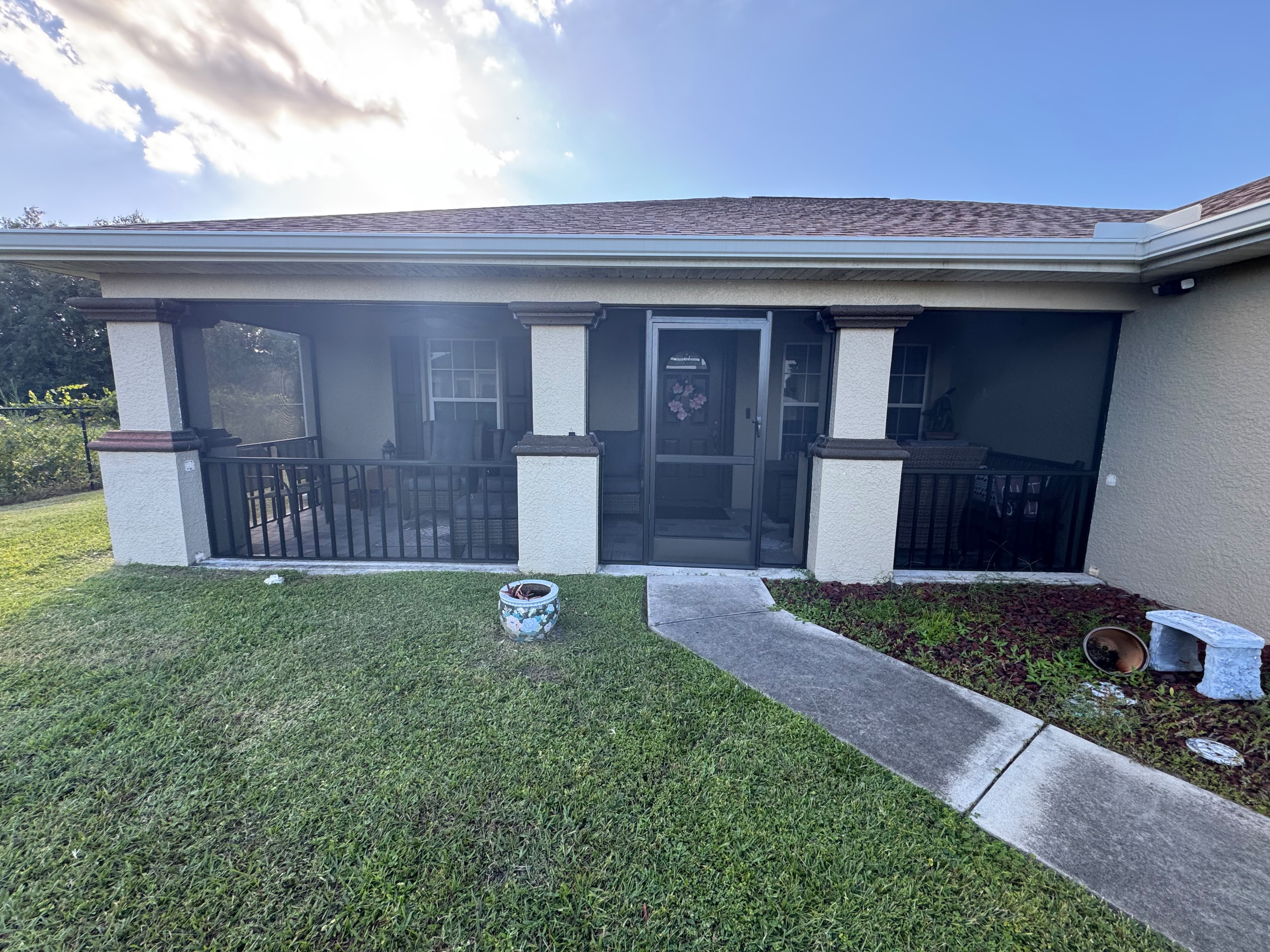 Wide screened lanai with access doors and an adjoining lawn