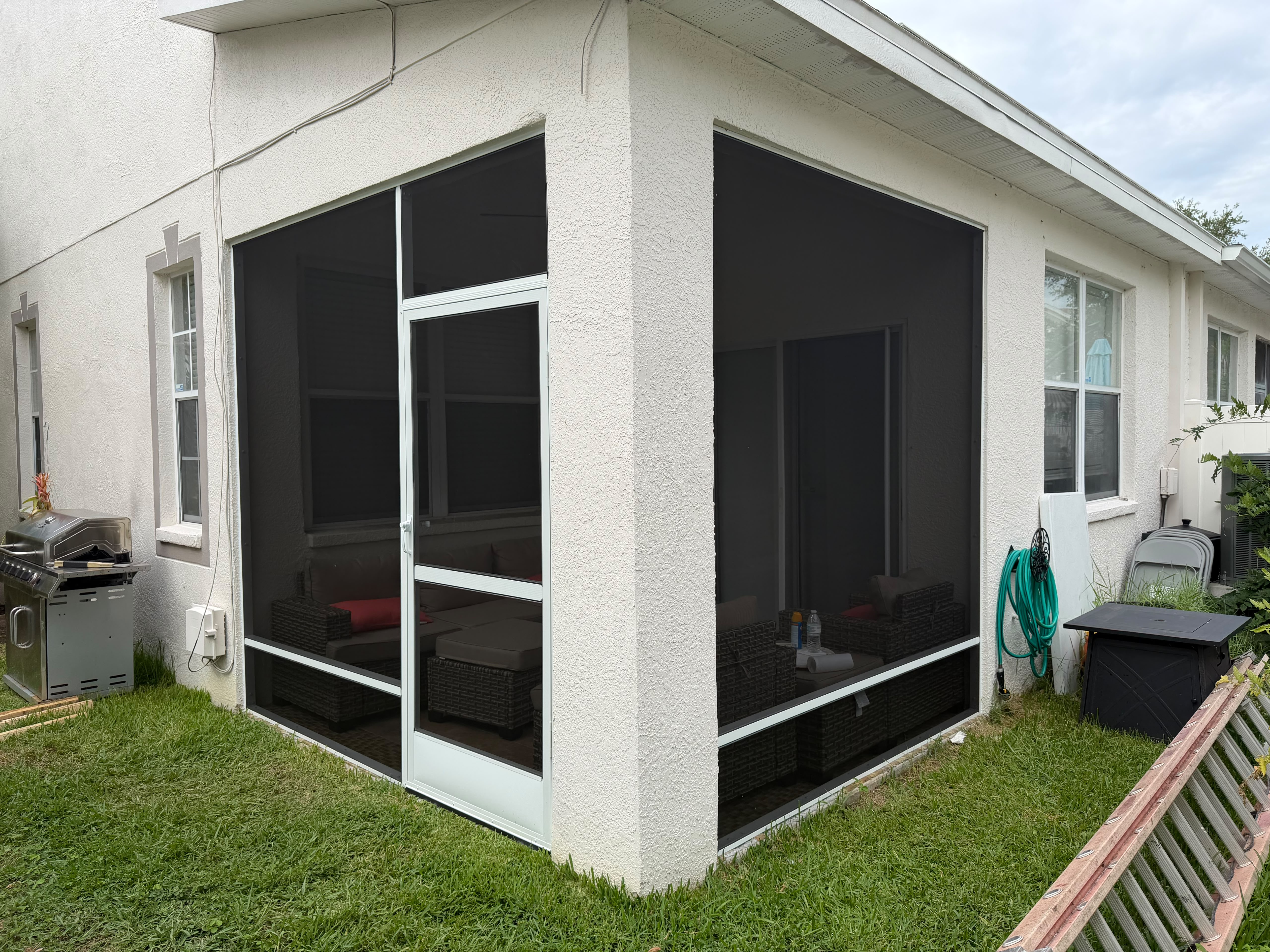 Completed white framed screening around an existing covered outdoor seating area