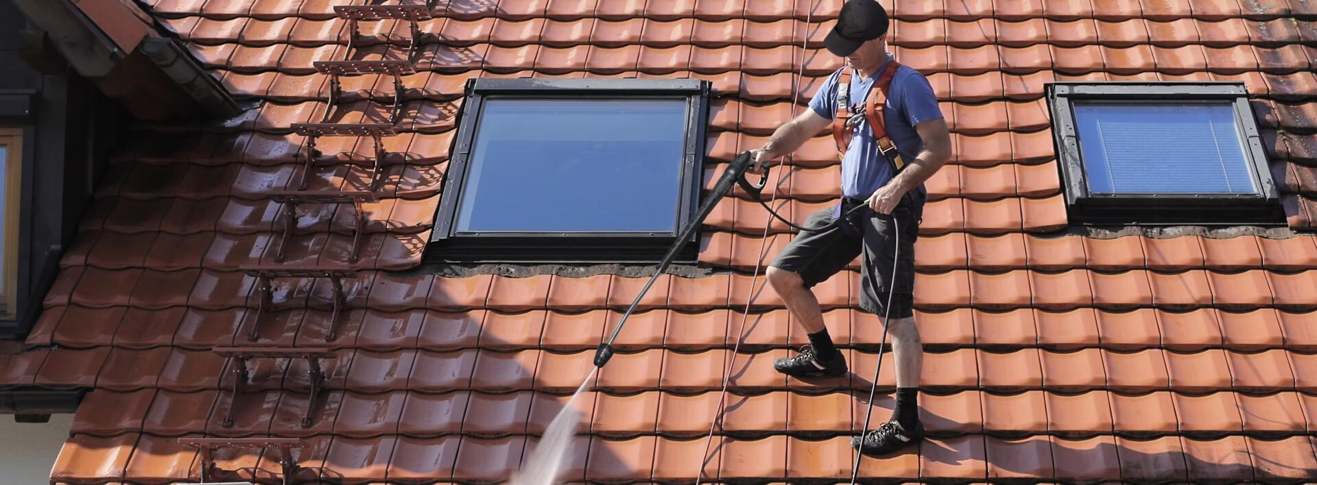 Southeast Cleaning Services technician soft-washing a tile roof