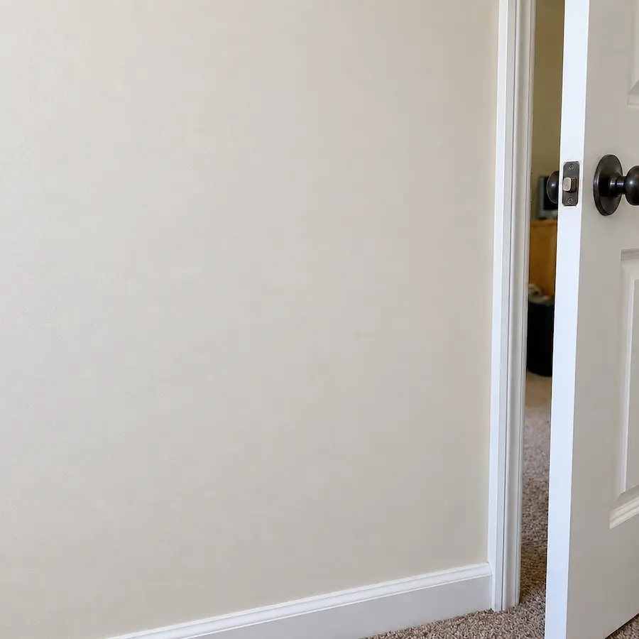 The same wall repaired and repainted warm white, with no visible patch